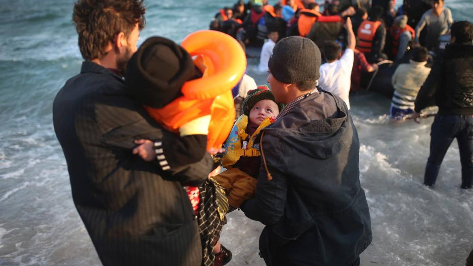 Refugees and migrants abort their effort on a dingy as they set out, trying to travel from the Turkish coast to the Greek island of Chios, near Cesme, Turkey, Saturday, Oct. 31, 2015. (AP Photo/Emre Tazegul)