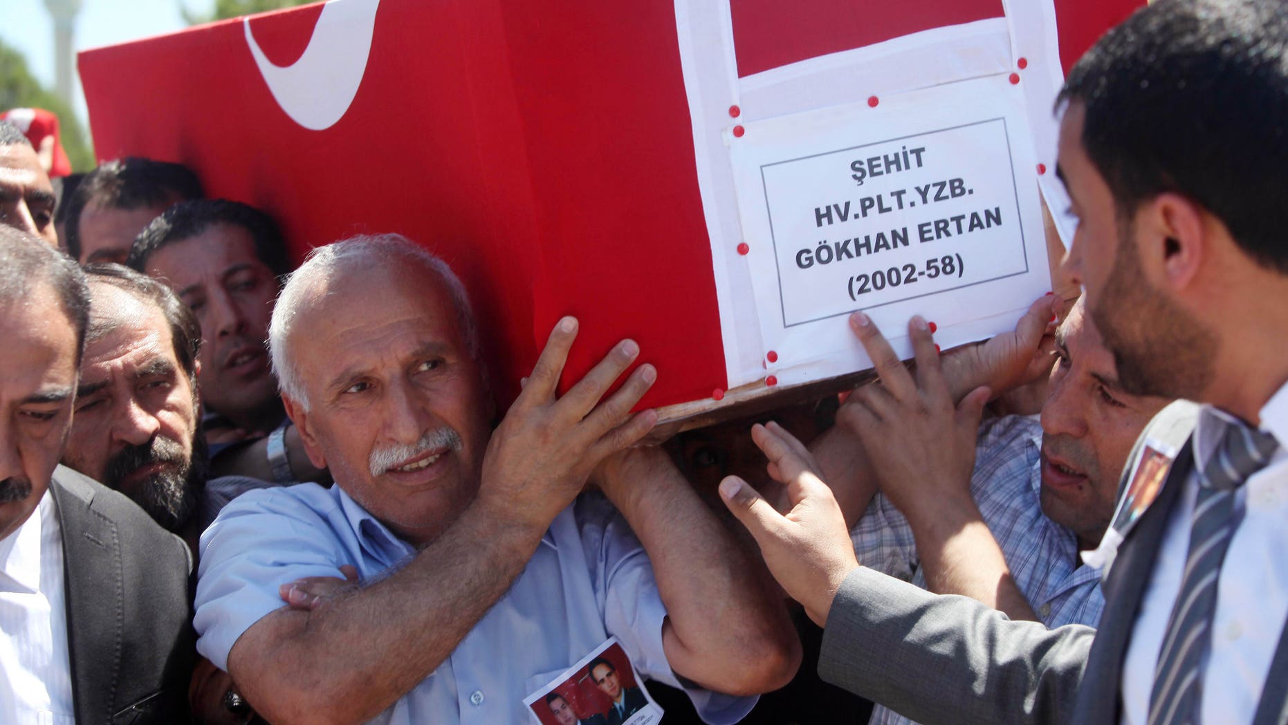 Ali Ertan, center, carries the coffin of his son, Captain Gokhan Ertan, after a religious funeral at a mosque in the eastern Turkish city of Malatya, Turkey, Friday, July 6, 2012. Turkey's Prime Minister Recep Tayyip Erdogan and top military commanders has joined hundreds of mourners at the funeral of two pilots whose jet was shot down by Syria two weeks ago. The somber ceremony took place at an air base in Malatya, from where the pilots' plane had originally taken off.(AP Photo)