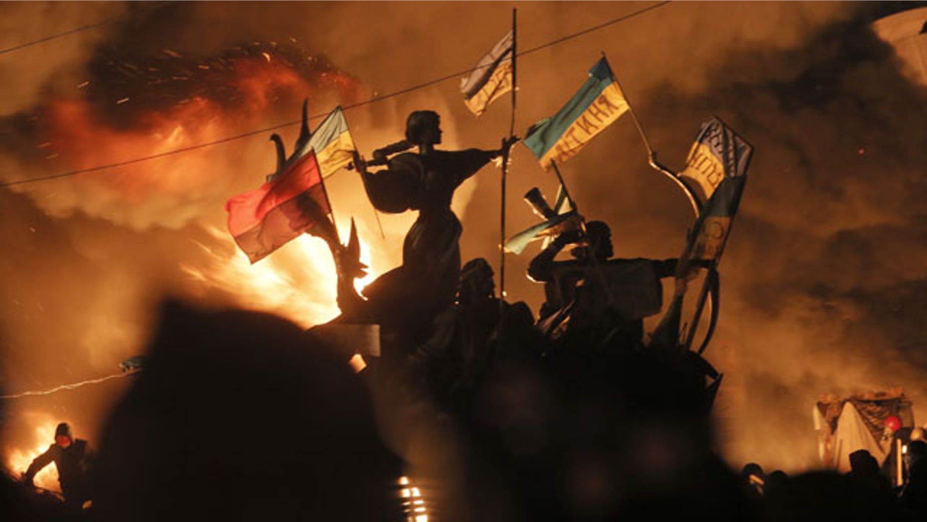 February 18, 2014: Monuments to Kiev's founders burn as anti-government protesters clash with riot police in Independence Square, the epicenter of Ukraine's current unrest. (AP)