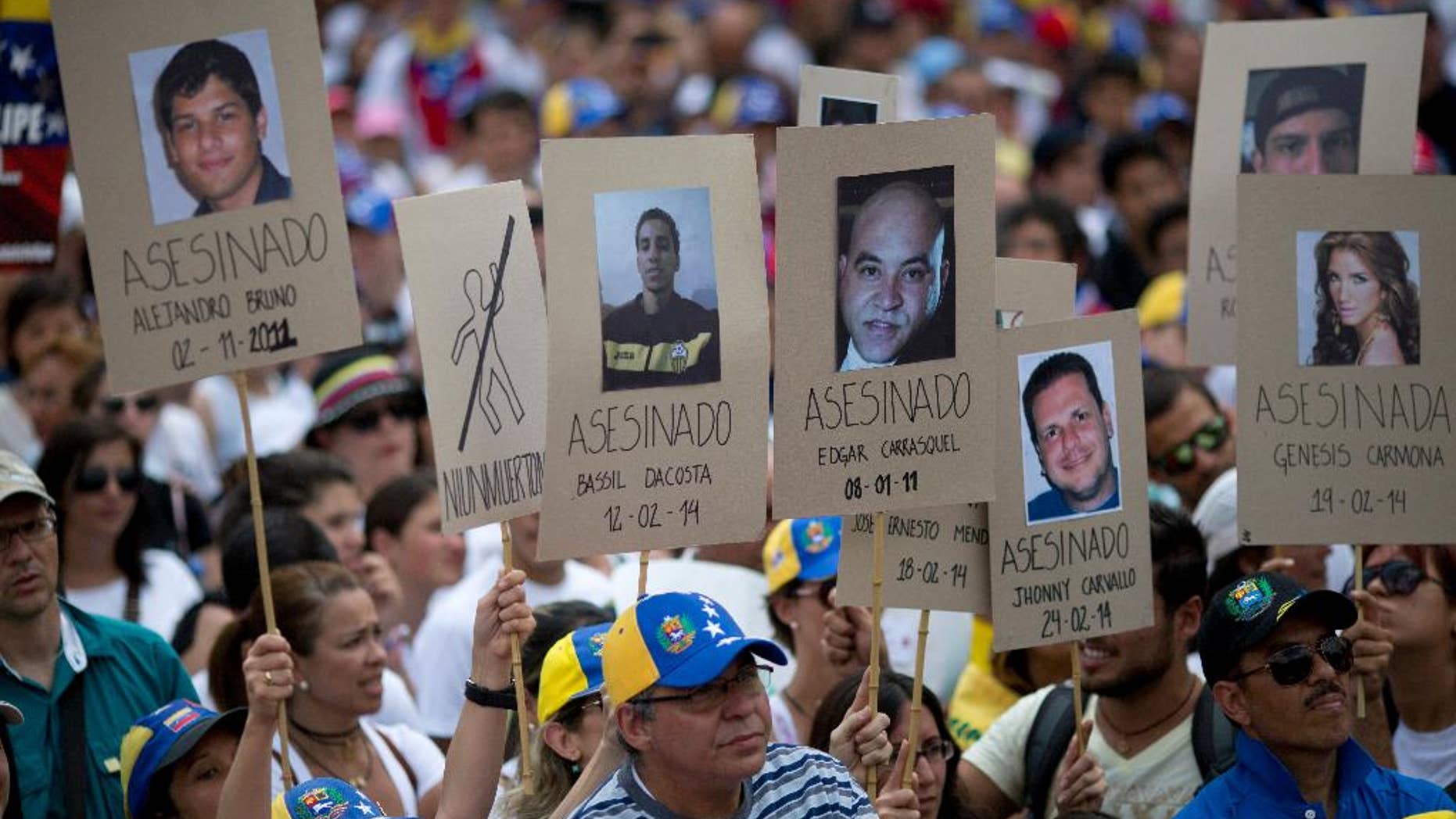 Demonstrators hold up posters with images of Venezuelans who were killed in the past two weeks during the recent unrest, at a rally with human rights activists in Caracas, Venezuela, Friday, Feb. 28, 2014. The start of a weeklong string of holidays leading up to the March 5 anniversary of former President Hugo Chavez's death has not completely pulled demonstrators from the streets as the government apparently hoped. President Nicolas Maduro announced this week that he was adding Thursday and Friday to the already scheduled long Carnival weekend that includes Monday and Tuesday off, and many people interpreted it as an attempt to calm tensions. (AP Photo/Rodrigo Abd)