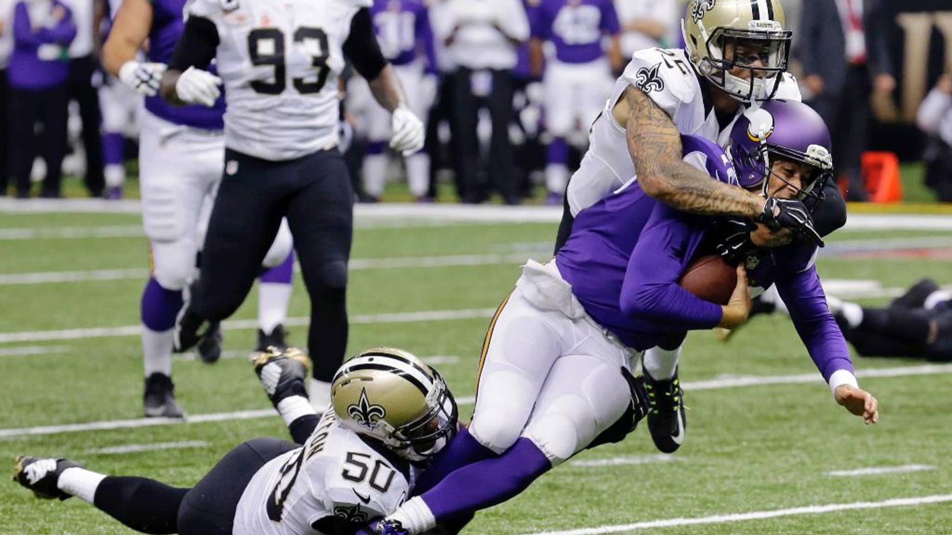 Minnesota Vikings quarterback Matt Cassel (16) is tackled by New Orleans Saints middle linebacker Curtis Lofton (50) and strong safety Kenny Vaccaro (32) in the first half of an NFL football game in New Orleans, Sunday, Sept. 21, 2014. Cassel injured his foot injury on the play. (AP Photo/Bill Haber)