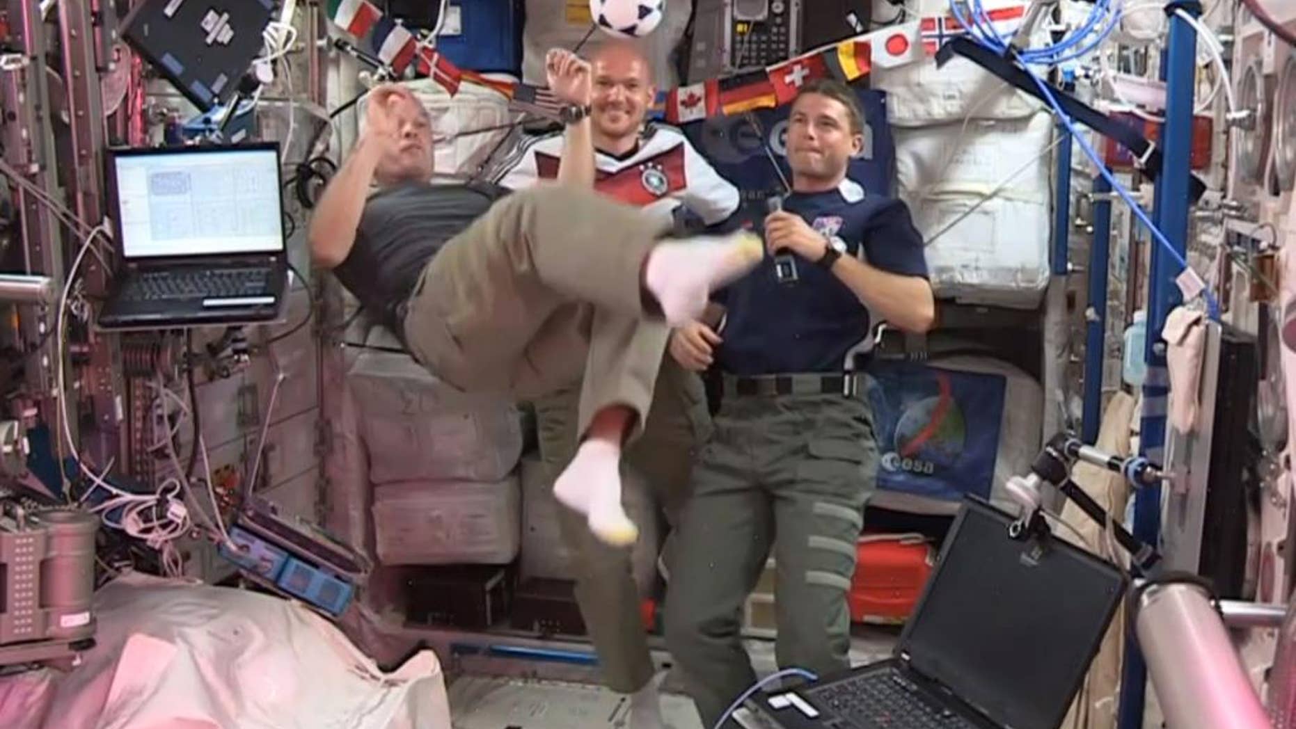 In this undated frame grab from video provided by NASA, United States astronauts Steve Swanson, left, Reid Wiseman, right, and German astronaut Alexander Gerst, center, kick around a soccer ball some 230 miles above Earth aboard the International Space Station. The astronauts say they will be watching the World Cup games. (AP Photo/NASA)