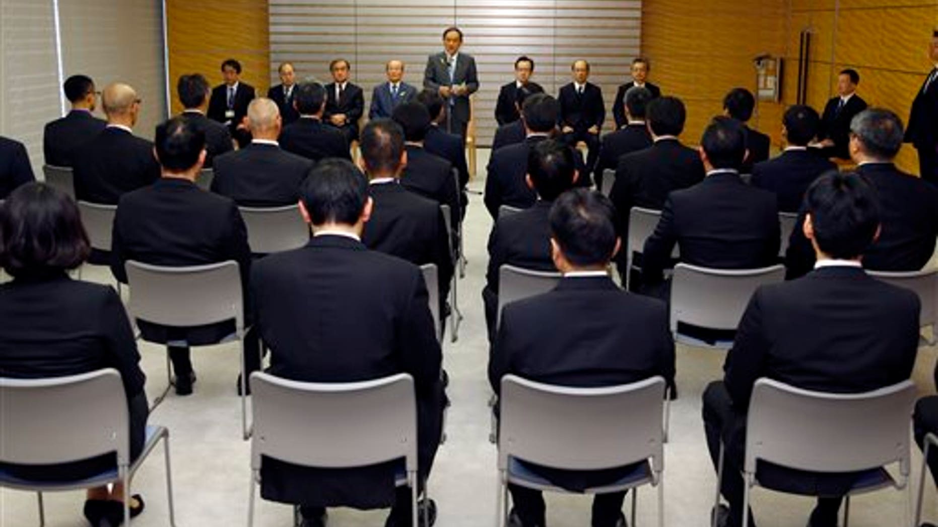 Japanese Chief Cabinet Secretary Yoshihide Suga, rear center, speaks during a ceremony to launch a special intelligence unit at the prime minister's official residence in Tokyo, Tuesday, Dec. 8, 2015. Japan launched on Tuesday the specialized intelligence unit within the Foreign Ministry as the government steps up counter-terrorism in preparation to host a Group of Seven summit next year and the Olympic Games in Tokyo in 2020. (AP Photo/Shizuo Kambayashi, Pool)