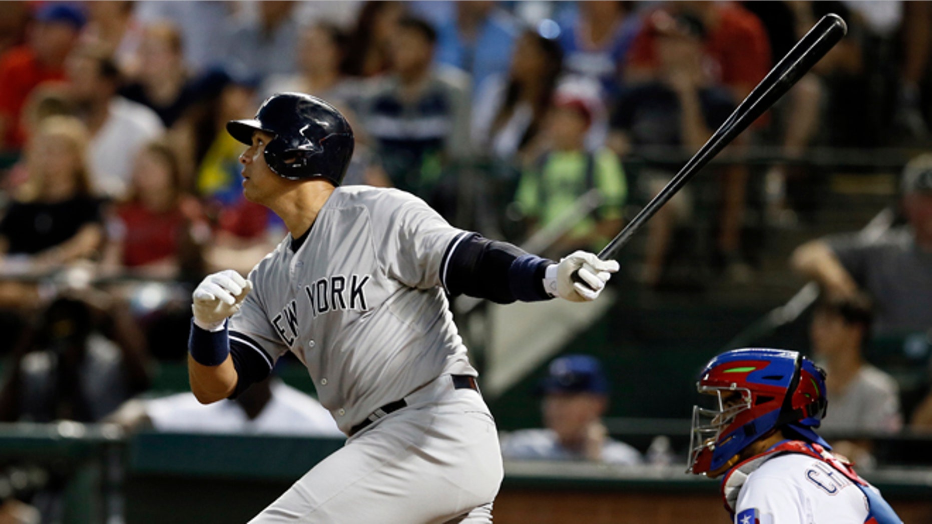 New York Yankees' Alex Rodriguez follows through on a solo home run swing off a pitch from Texas Rangers' Matt Harrison as Rangers catcher Robinson Chirinos watches in the sixth inning of a baseball game Monday,July 27, 2015, in Arlington, Texas. (AP Photo/Tony Gutierrez)