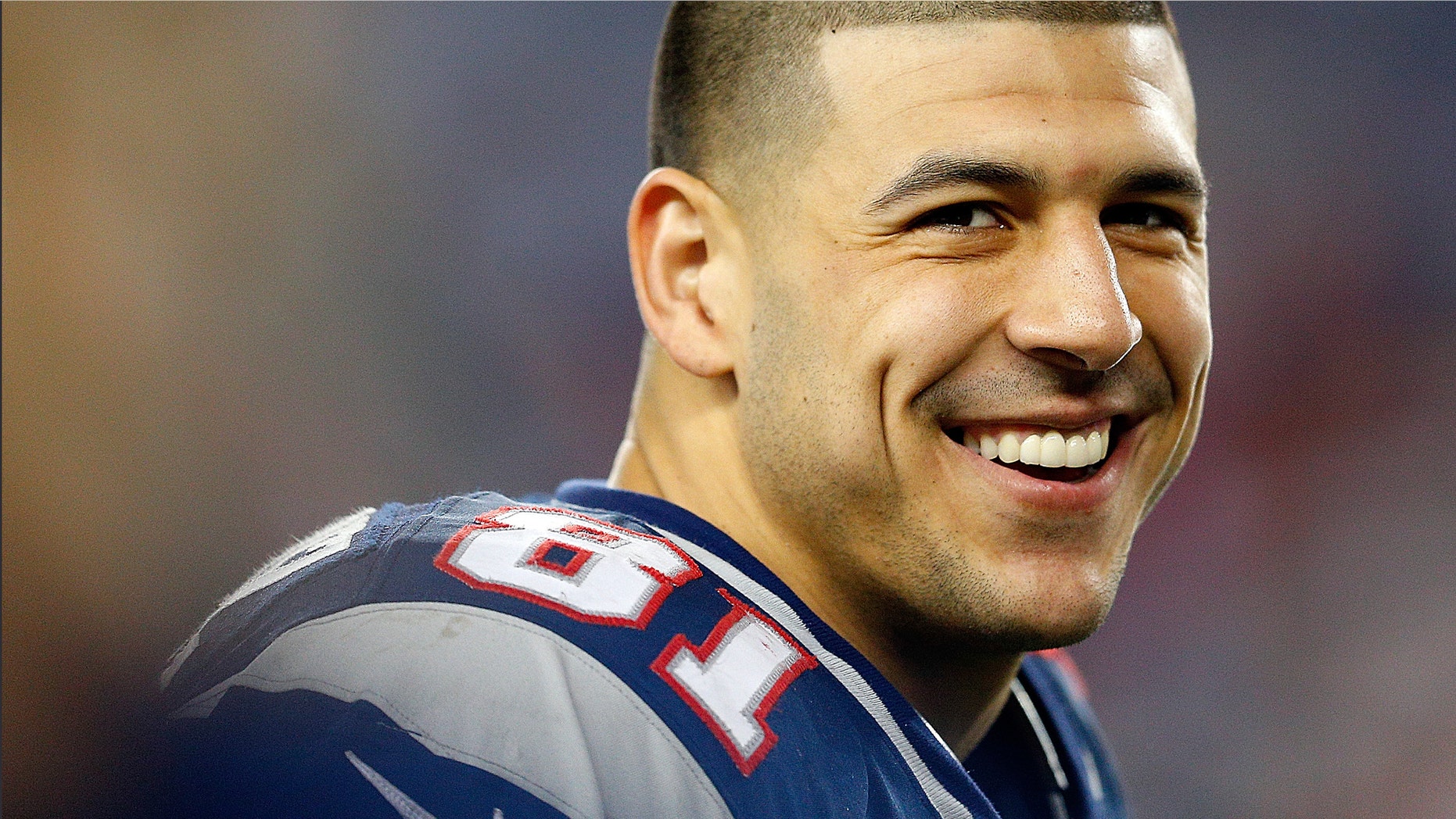 Aaron Hernandez #81 of the New England Patriots smiles from the sidelines in the fourth quarter during a game against the Houston Texans at Gillette Stadium on December 10, 2012 in Foxboro, Massachusetts. (Photo by Jim Rogash/Getty Images)