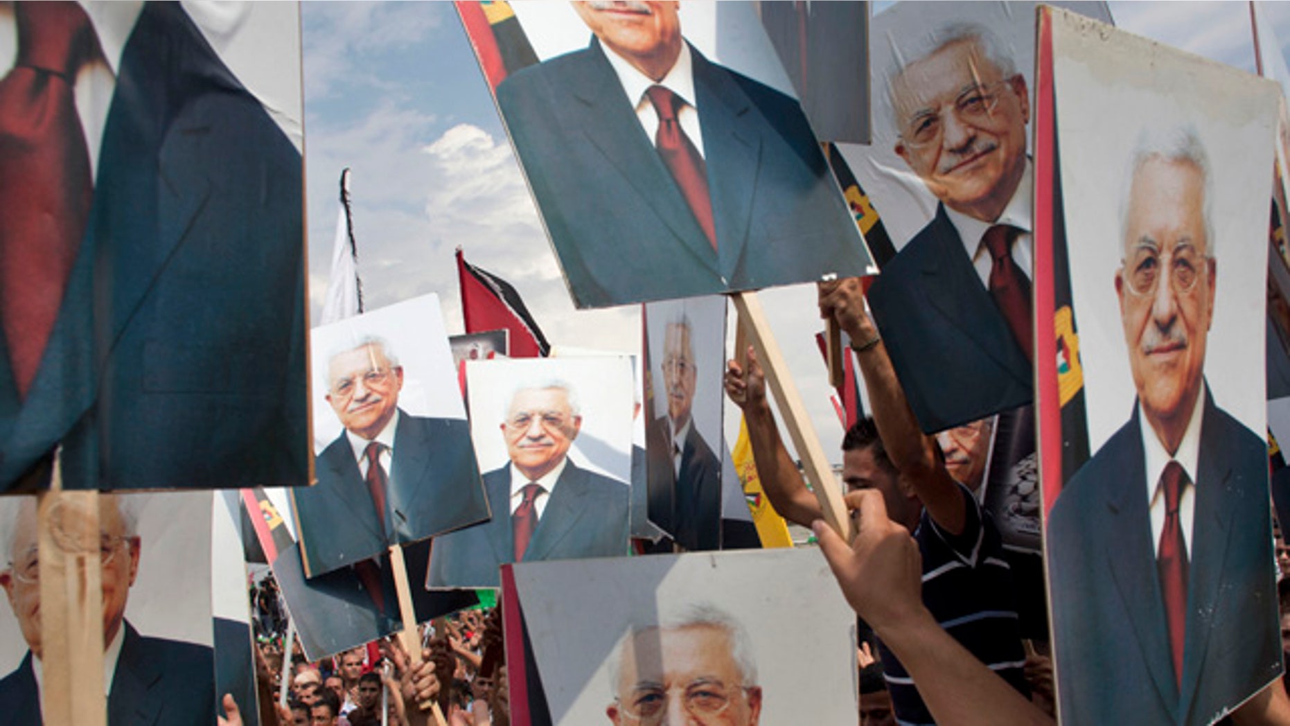 Sept. 25: Palestinians hold pictures of Palestinian President Mahmoud Abbas at the government compound, in the West Bank city of Ramallah.