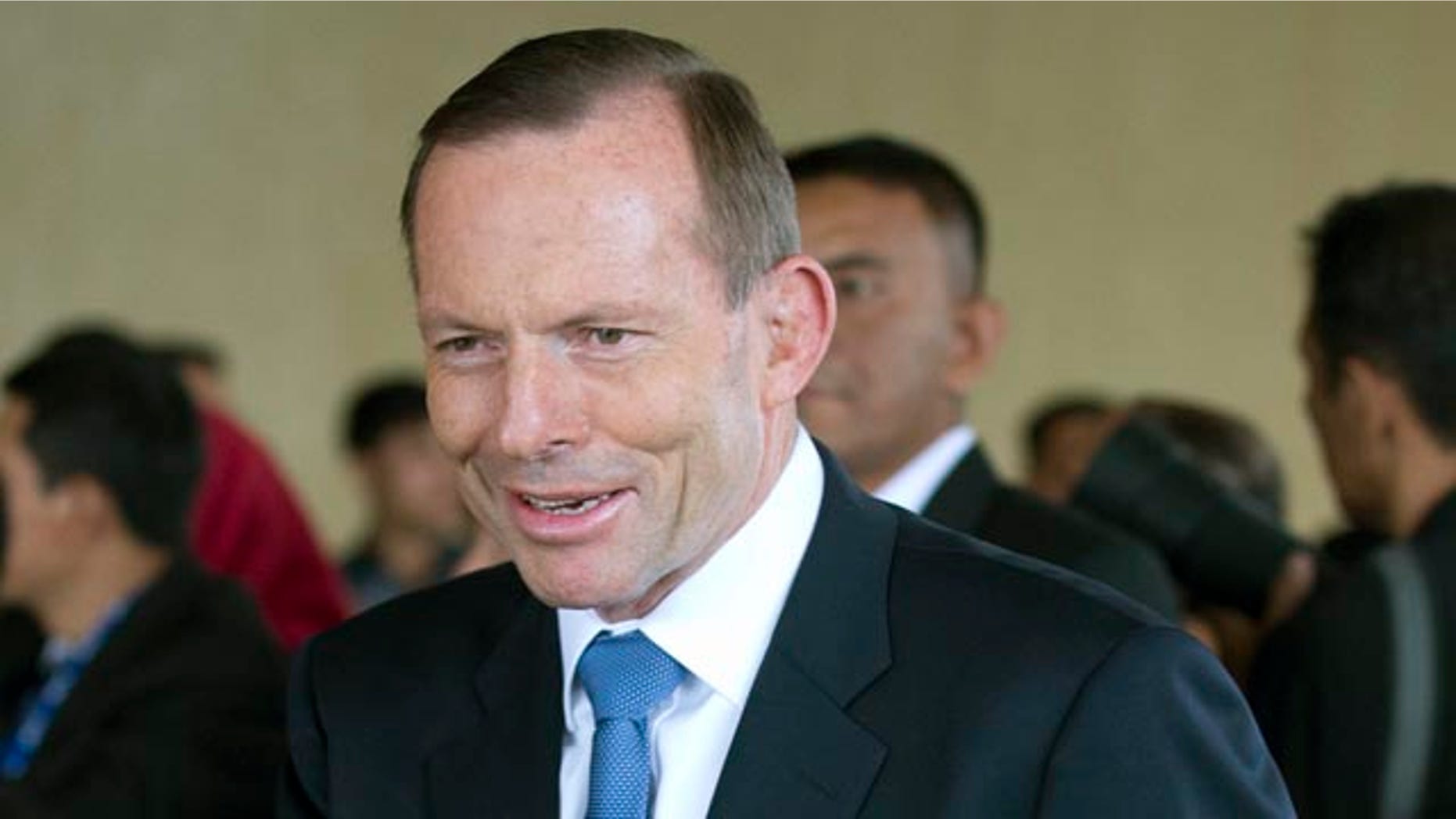 October 20, 2014: Australian Prime Minister Tony Abbott waves as he arrives for the inauguration of Indonesian President Joko Widodo at Parliament in Jakarta. (AP Photo/Mark Baker)