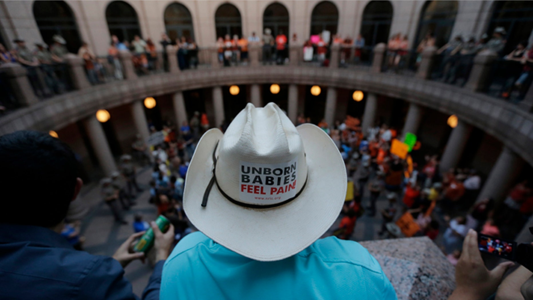 Opponents and supporters of an abortion bill gather in a courtyard outside a hearing for the bill at the state capitol, Tuesday, July 2, 2013, in Austin, Texas. Gov. Rick Perry has called lawmakers back for another special session with abortion on the top of the agenda. (AP Photo/Eric Gay)