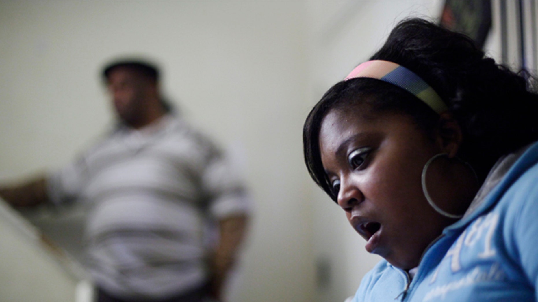 Jan. 21, 2011: Davida Johnson, 30, seen with her husband Bobby Johnson, reacts as she reads a grand jury report brought to her by the Associated Press during an interview in Philadelphia. Johnson believes she contracted a venereal disease while undergoing an abortion in 2001 at Dr. Kermit Gosnell's clinic, and says she has since had four miscarriages.