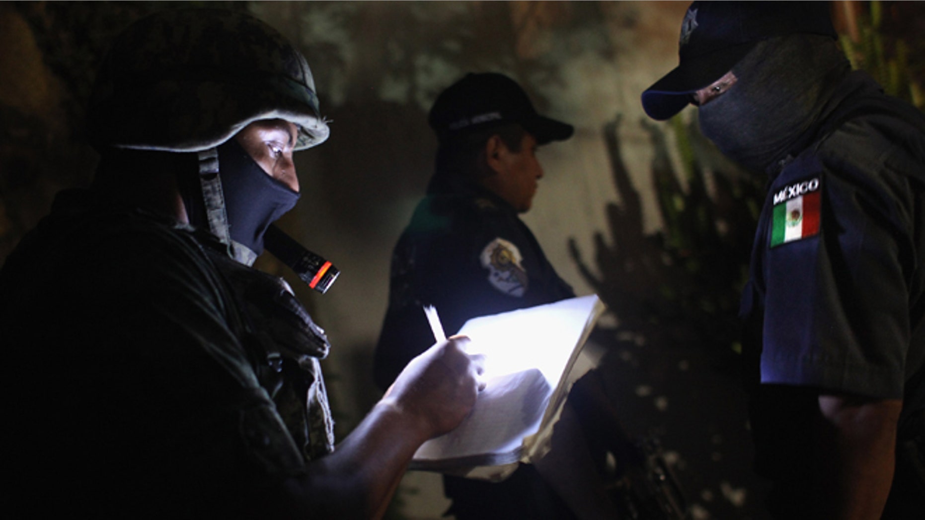 ACAPULCO, MEXICO - MARCH 03: A Mexican soldier takes notes at a suspected drug-related murder site late March 3, 2012 in Acapulco, Mexico. A forensics team excavated five corpses from the floor of an abandoned house. Officials said the five victims were apparently buried alive in concrete. Drug violence has surged in the coastal resort in the last year, making Acapulco the second most deadly city in Mexico after Juarez. One of Mexico's top tourist destinations, Acapulco has suffered a drop in business, especially from foreign tourists, due to the violence. Toursim accounts for about 70 percent of the economy of Acapulco's state of Guerrero and 9 percent of Mexico's economy. (Photo by John Moore/Getty Images)