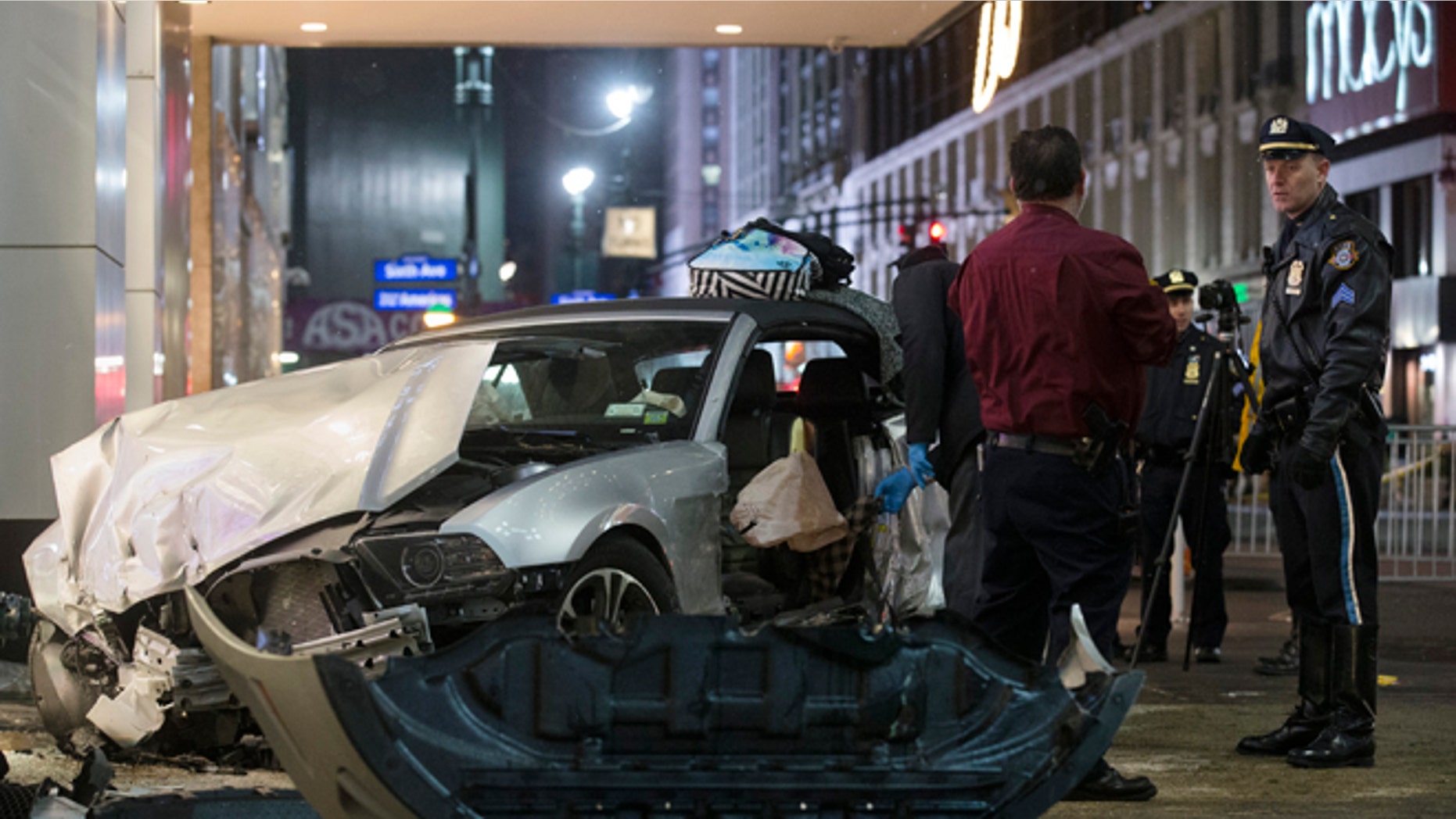 Police search a car at the scene of a vehicular accident on 34th Street, Thursday, Dec. 11, 2014, in New York. Six people were hurt when the car jumped a curb in midtown Manhattan and struck a group of people around 10 p.m. A fire department spokesman says the injured were taken to Bellevue hospital with serious but non-life threatening injuries. (AP Photo/John Minchillo)