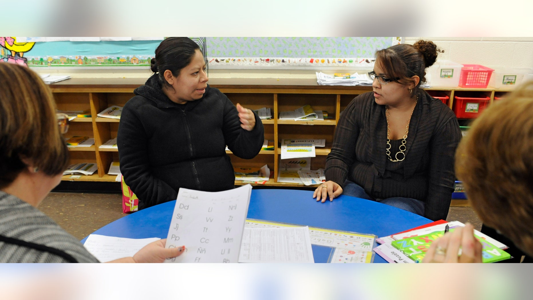 In this Friday, Dec. 2, 2011 photo, parent liaison Ana Lozada, second from right, translates Spanish to English for parent Blanca Salas, second from left, as bilingual teacher Millie Vera, left, and special education teacher Kathy Bentley meet with Salas during a parent-teacher conference for her daughter Lizbeth at Windham Center School in Windham, Conn. Connecticut's investment in teaching of English as a second language declined steadily over the last decade despite a 50 percent increase in the Latino population. (AP Photo/Jessica Hill)