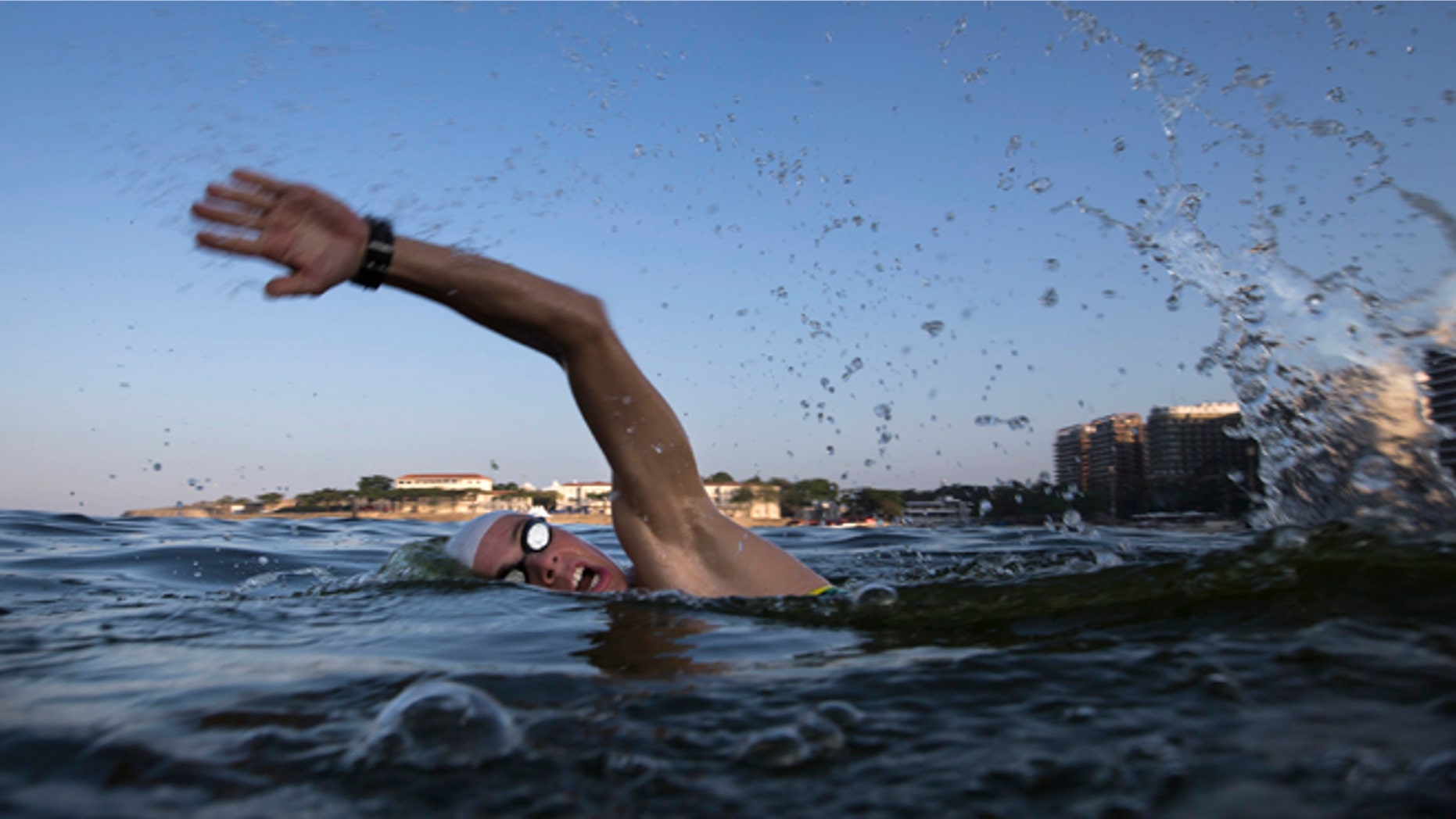FILE - In this July 31, 2015, file photo, a triathlete swims in the waters off Copacabana beach during training in Rio de Janeiro, Brazil. The World Health Organization's top water expert said Friday, Aug. 14, 2015, the body "never advised against viral testing" for Rio de Janeiro's polluted waterways where about 1,400 athletes will compete in Olympic events next year. Bruce Gordon, the WHO's coordinator of water, sanitation, hygiene and health, told The Associated Press in a phone interview from Geneva that testing for viruses "would be advisable" given it is known that human sewage pollution is rife in Rio's waters. (AP Photo/Felipe Dana, File)