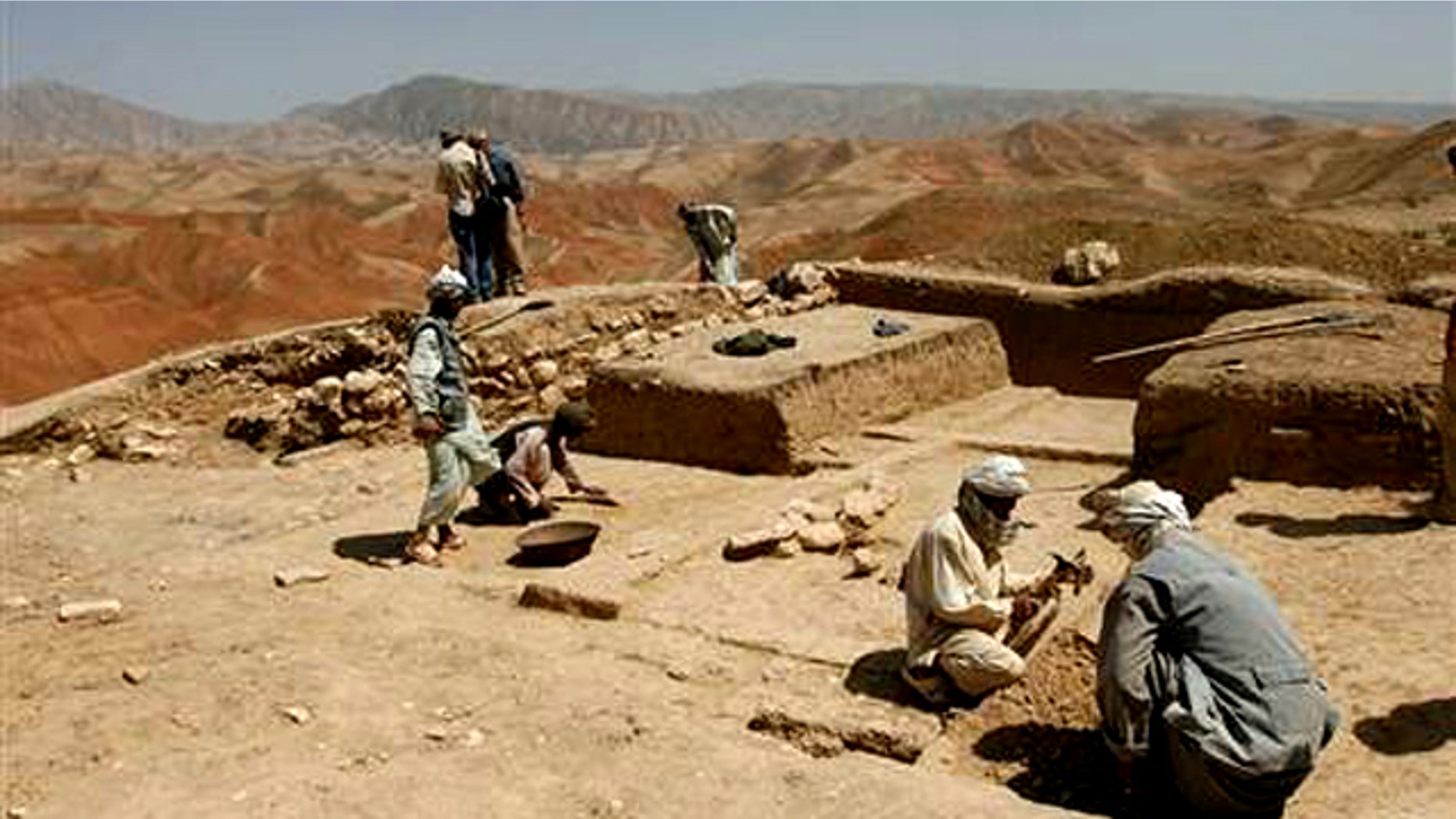 In 2008, Afghan archaeologists are seen digging the baked earth on the heights of Cheshm-e-Shafa in the Balkh province.