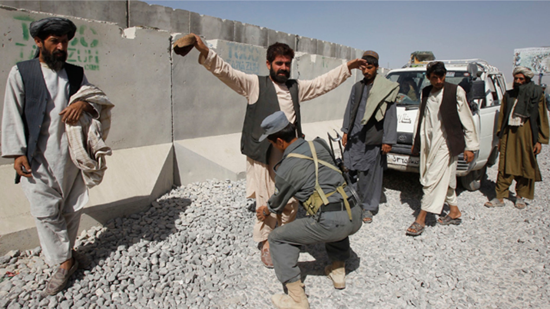 Oct. 6, 2010: An Afghan policeman checks passengers of a vehicle at a joint U.S. and Afghan military checkpoint in the outskirts of Kandahar. Afghan police say they have intercepted 22 tons of explosives reportedly imported from neighboring Iran.