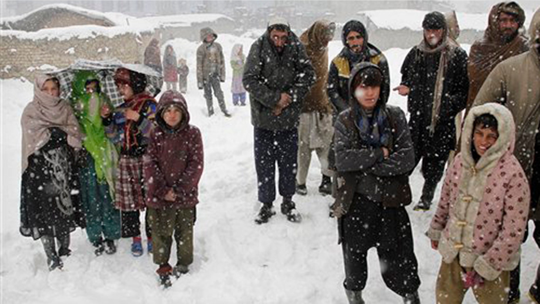 FILE: Afghans wait to receive blankets and winter jackets from Welthungerhilfe, a German NGO, during a snow fall at a camp for internally displaced people in Kabul.
