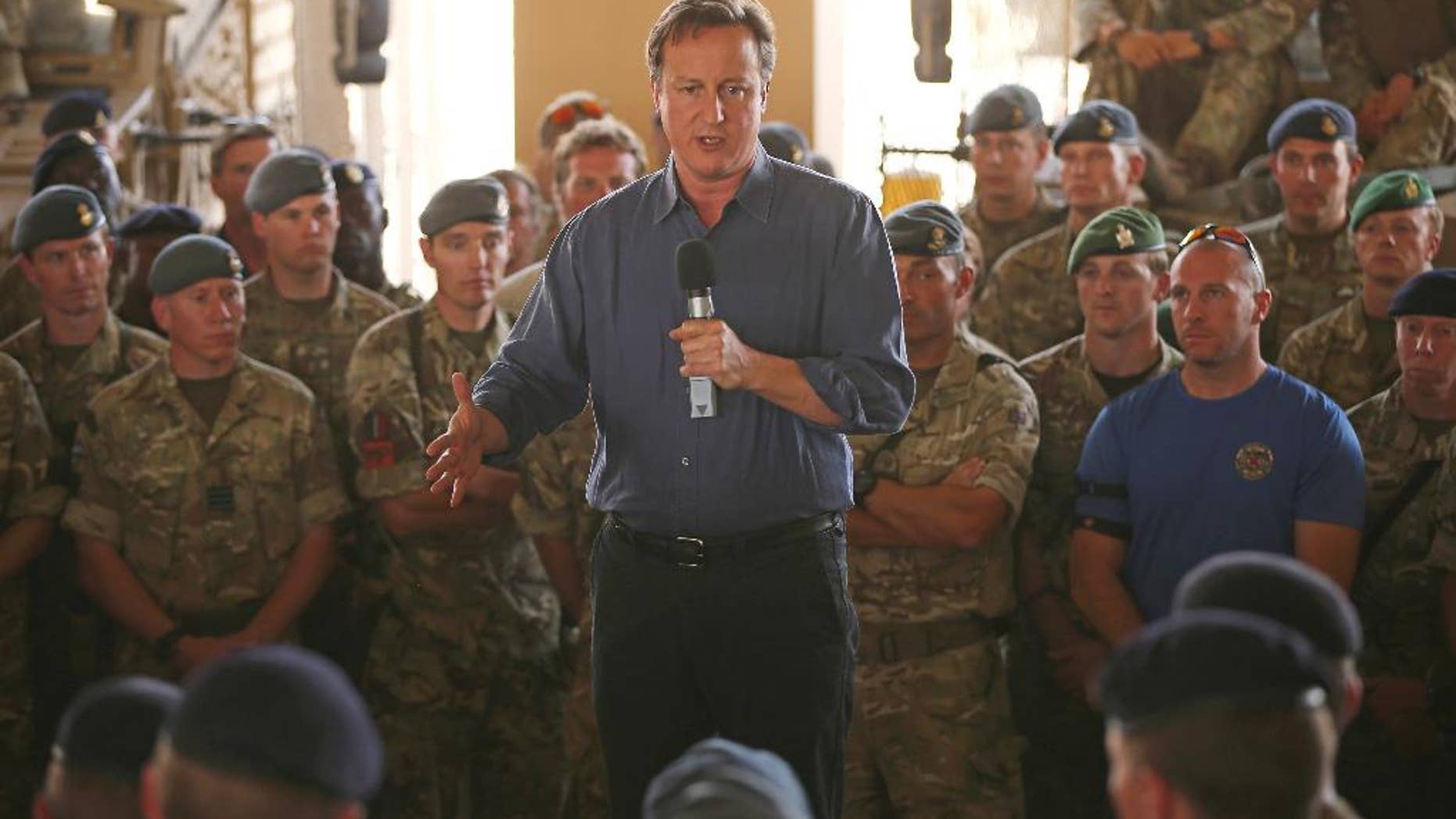 Britain's Prime Minister David Cameron, centre, addresses British troops, in Camp Bastion, Afghanistan, Friday, Oct. 3, 2014. Cameron on Friday pledged support for Afghanistan's newly sworn-in president and the country's new unity government, saying during a surprise visit to Kabul that Britain is committed to helping Afghans build a more secure and prosperous future. (AP Photo/Dan Kitwood, Pool)