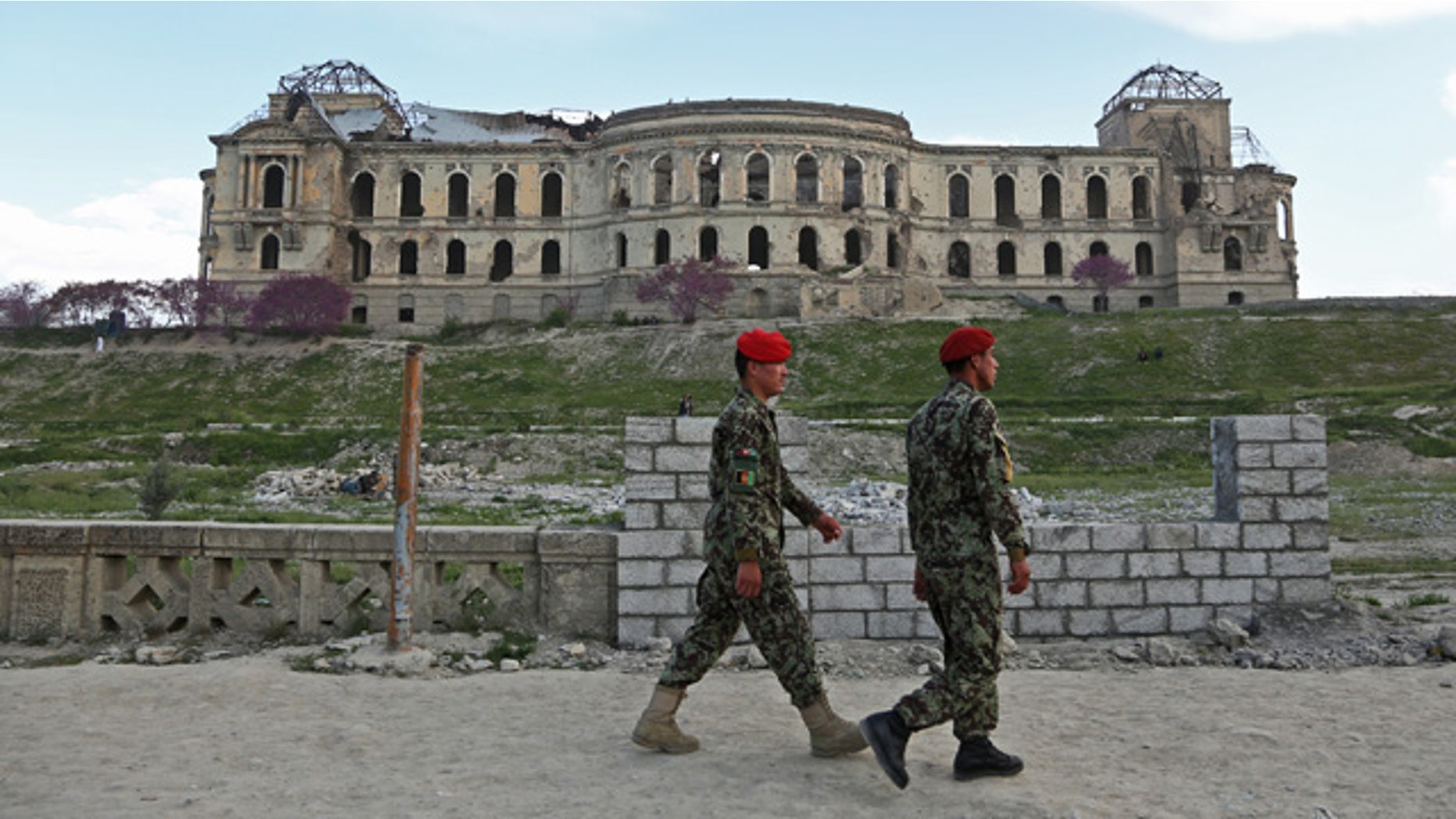 April 27, 2014: Afghan national army soldiers walk past the palace of the late King Amanullah Khan, which was destroyed during the civil war of the early 1990s, in Kabul. (AP Photo/Rahmat Gul)