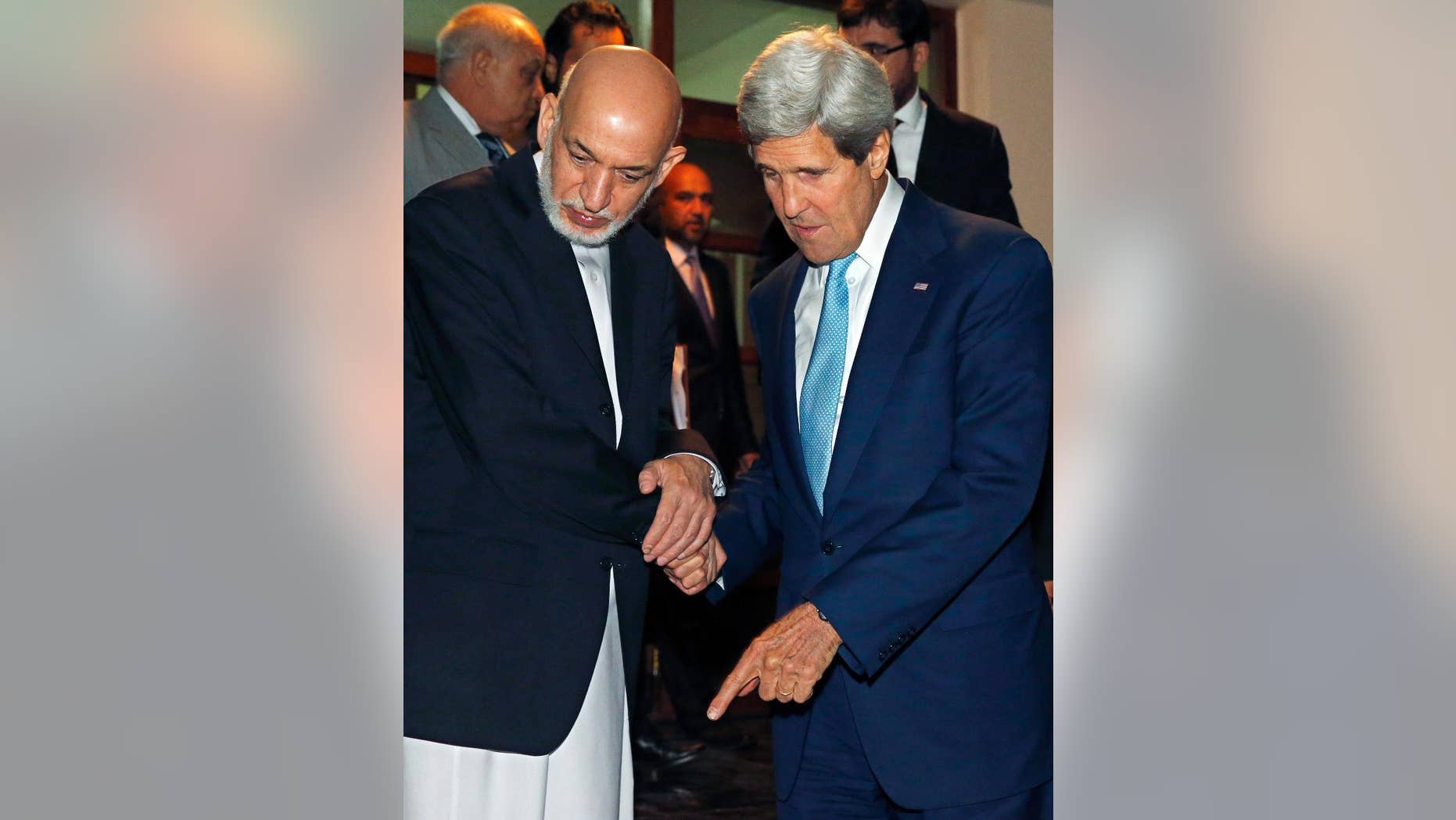 U.S. Secretary of State John Kerry, right, and Afghanistan's President Hamid Karzai talk as Karzai says goodbye to Kerry after a dinner at the presidential palace in Kabul, Afghanistan, Friday, July 11, 2014. Kerry visited Afghanistan in hopes of diffusing a crisis over the runoff presidential election to find a successor for outgoing President Karzai. (AP Photo/Jim Bourg, Pool)