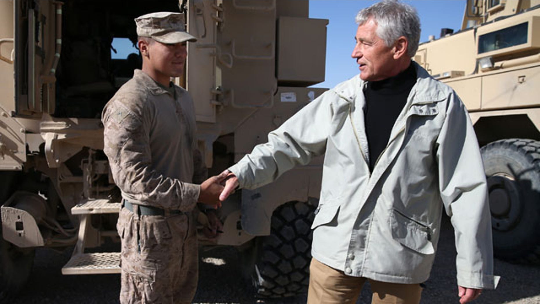 December 8, 2013: U.S. Secretary of Defense Chuck Hagel, right, shakes hands with U.S. Marine Lance Cpl. Arron Corona as he works on a MRAP vehicle, at Camp Bastion, Afghanistan. Hagel spoke with troops and thanked them for being deployed for the holidays. (AP Photo/Mark Wilson, Pool)