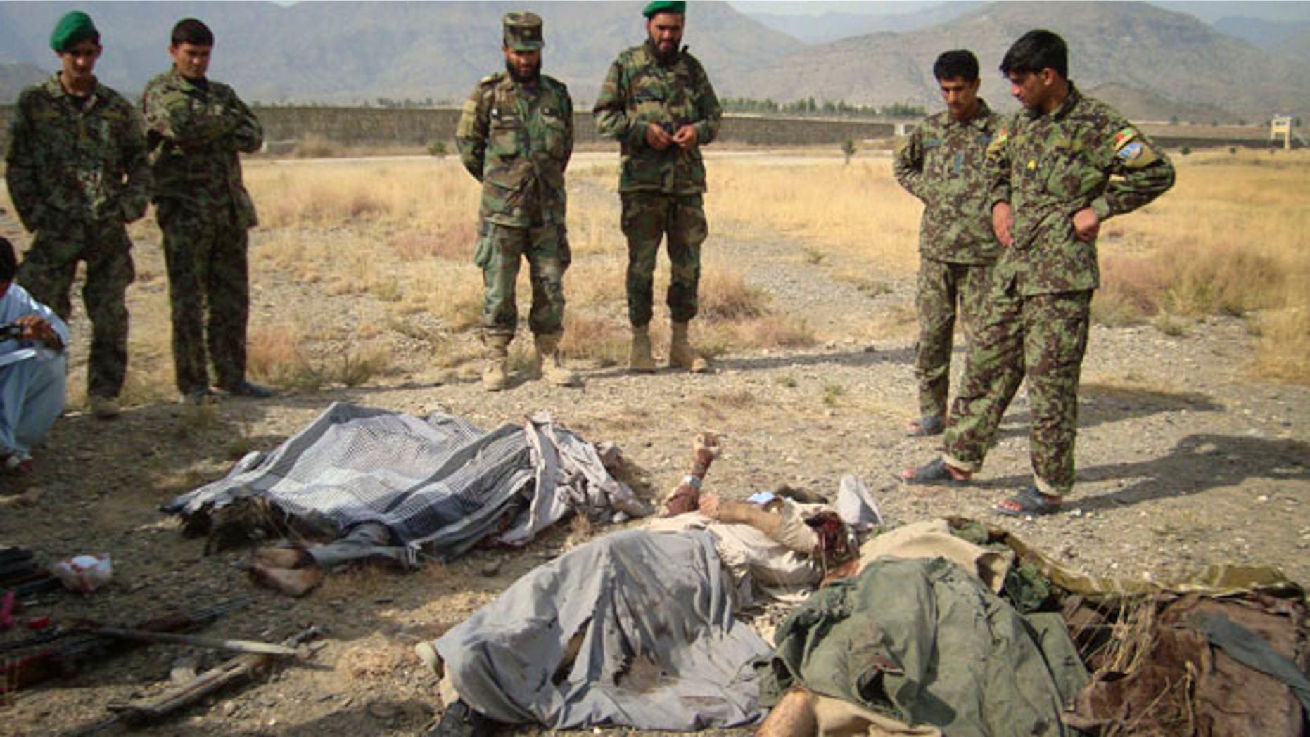 Nov 4: Afghan soldiers look over the bodies of Taliban militants killed by a coalition air strike in Khost, Afghanistan.