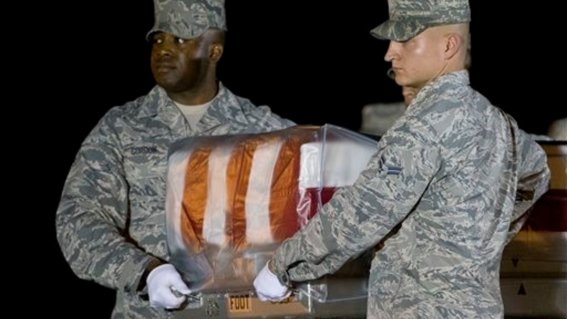 An Air Force carry team moves a transfer case containing the remains of Maj. Phyllis J. Pelky, Tuesday, Oct. 13, 2015, at Dover Air Force Base, Del. According to the Department of Defense, Pelky, 45, of Rio Rancho, N.M. died Oct. 11 in the crash of a British Puma Mk2 helicopter in Kabul, Afghanistan while supporting Operation Freedoms Sentinel. (AP Photo/Matt Rourke)