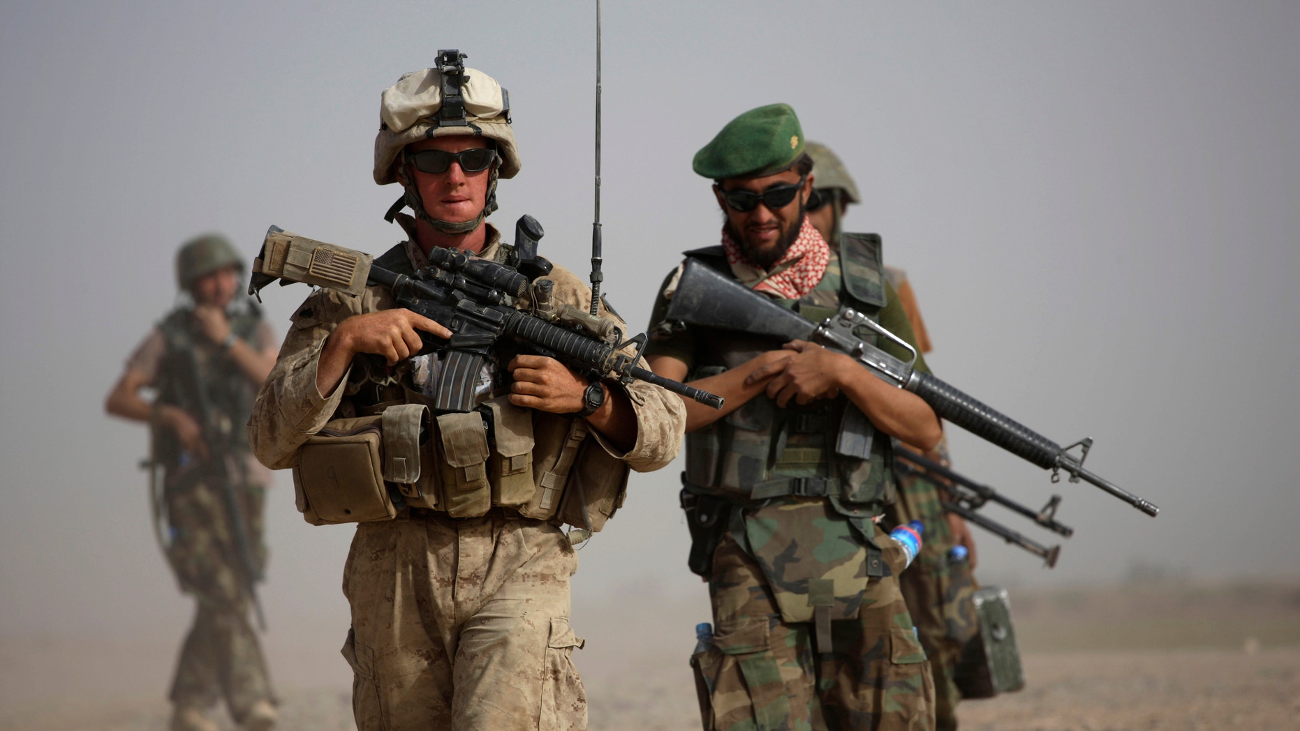 FILE: U.S. Marine squad leader Sgt. Matthew Duquette, left, of Warrenville, Ill., with Bravo Company, 1st Battalion 5th Marines walks with Afghan National Army Lt. Hussein, during in a joint patrol in Nawa district, Helmand province, southern Afghanistan.