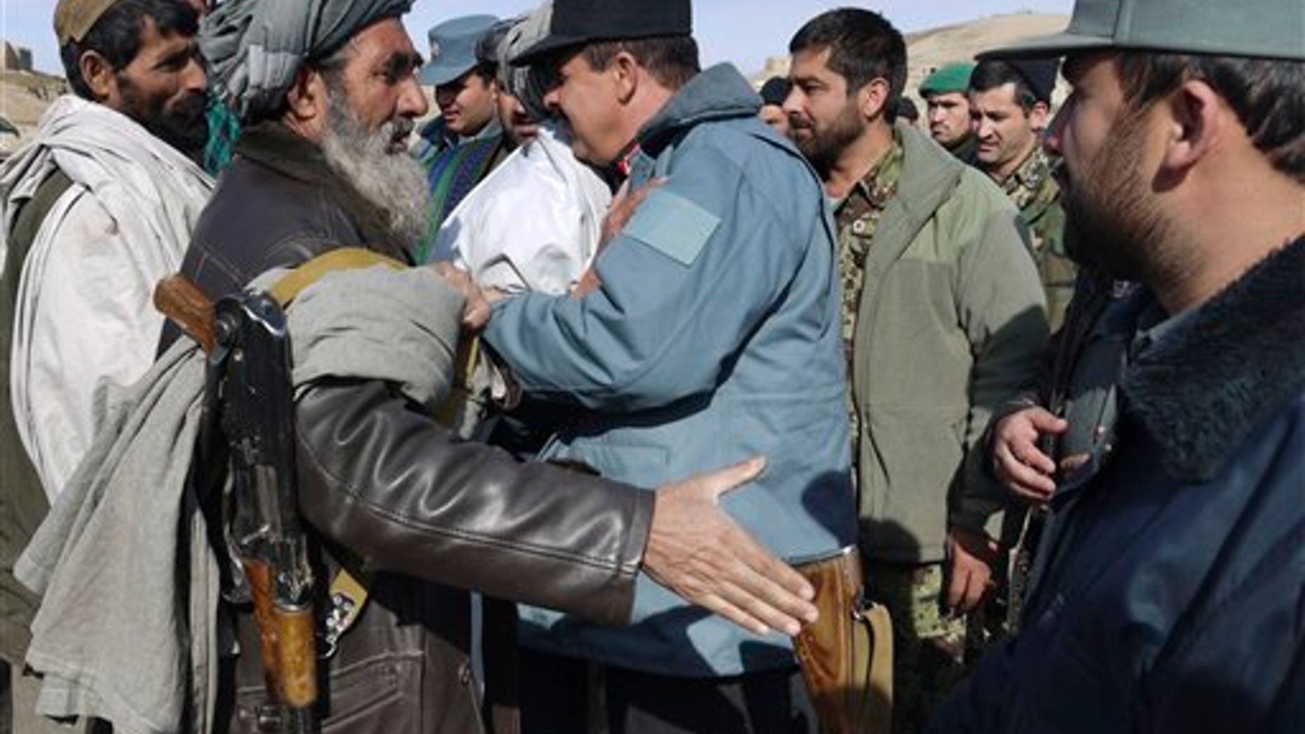 Jan. 24, 2012: A former Taliban militant, left, shakes hands with a police official during a joining ceremony with the Afghan government in Baghlan, north of Kabul, Afghanistan.