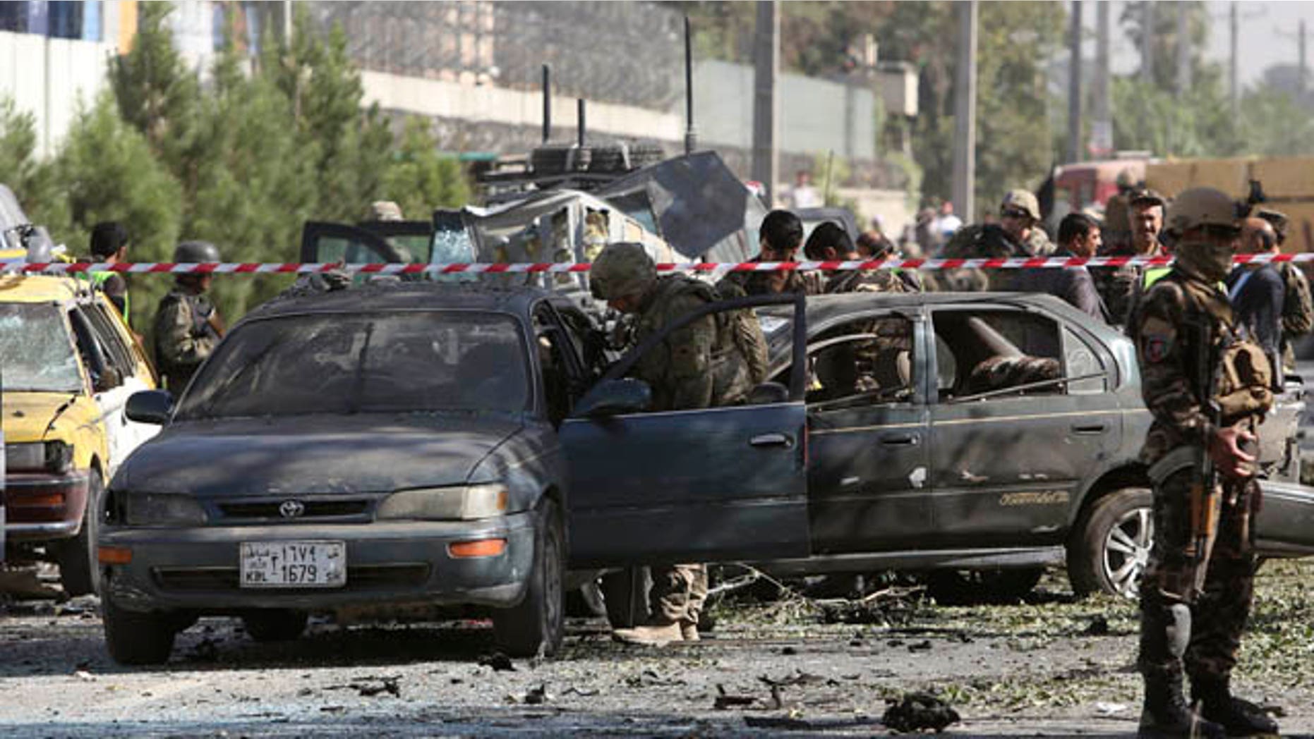 September 16, 2014: NATO and Afghan security forces inspect the site of a suicide attack in Kabul. (AP Photo/Rahmat Gul)