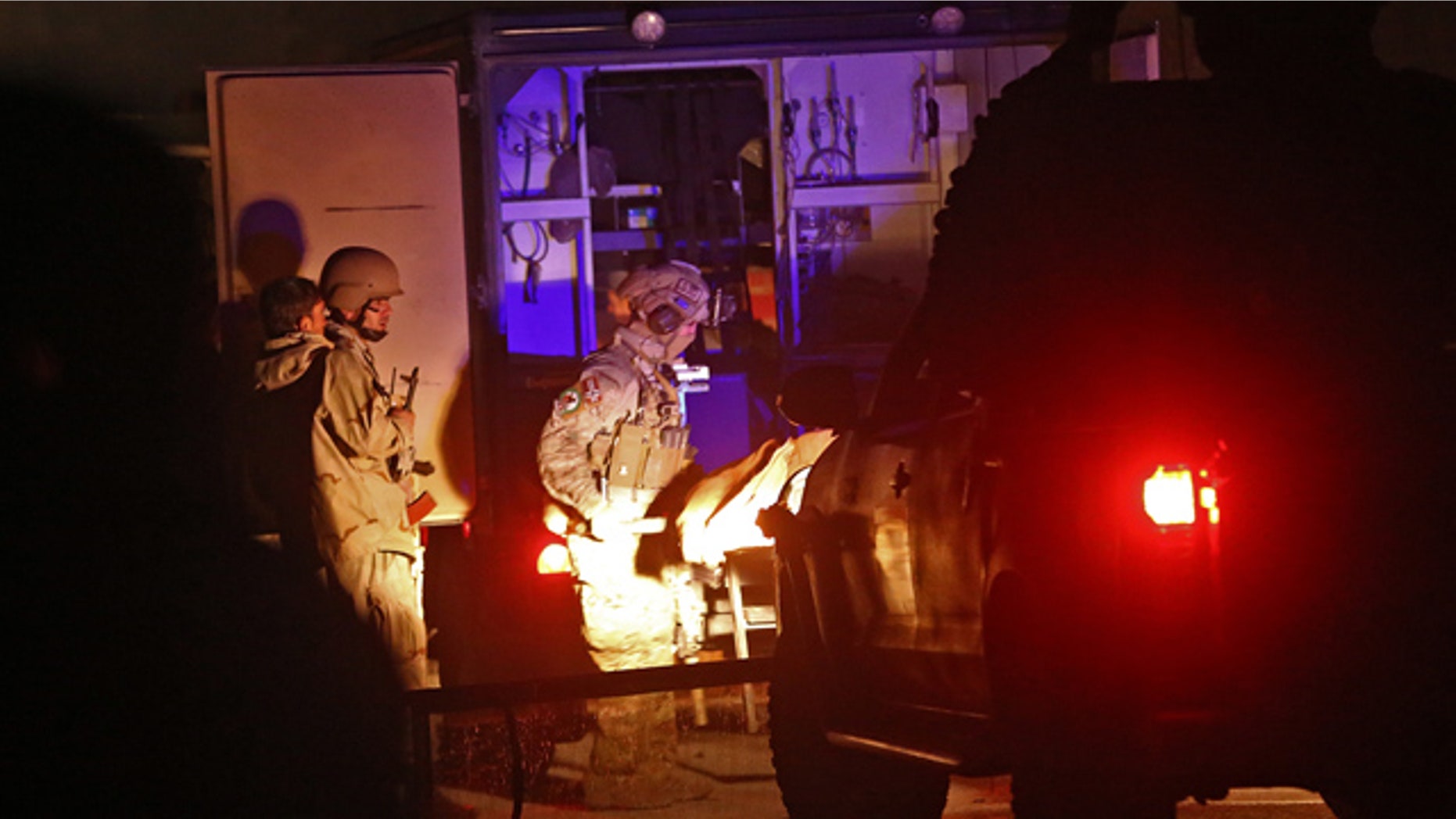November 29, 2014: Afghan security personnel carry a dead body into an ambulance at the site of a battle between security forces and Taliban fighters in Kabul. (AP Photo/Massoud Hossaini)
