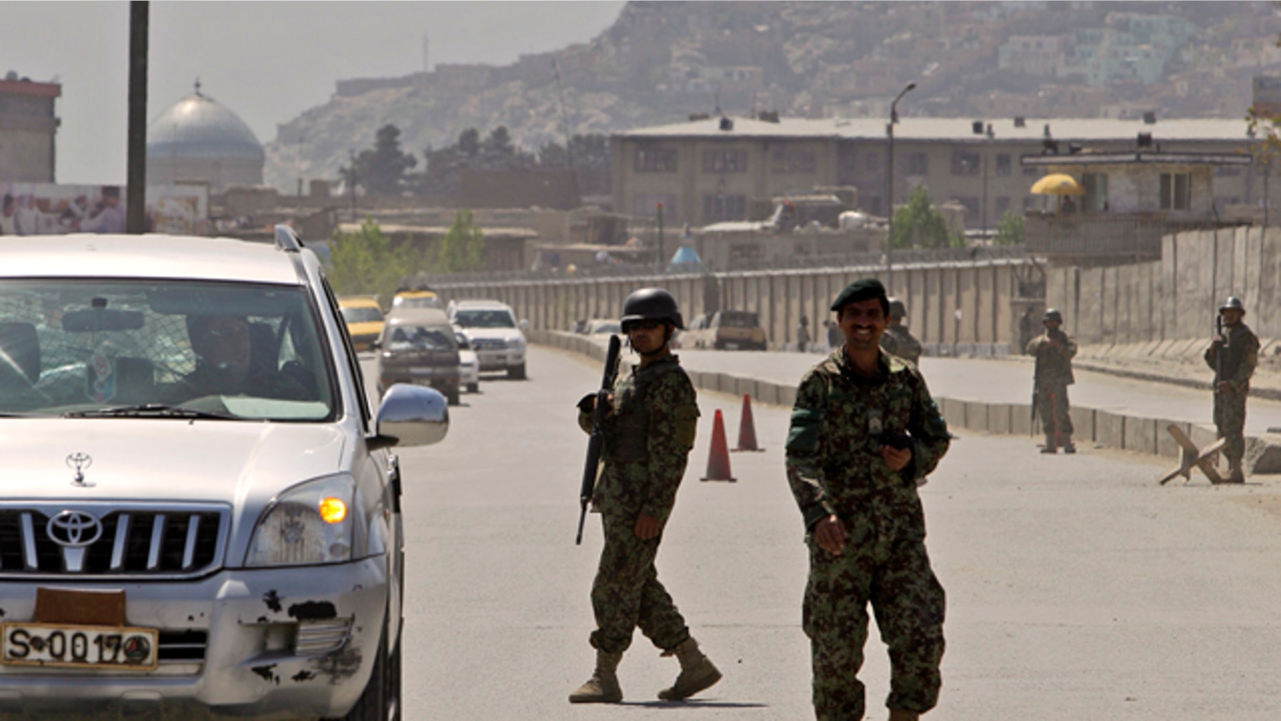 April 18: Afghan security officers secure the road near the Defense Ministry in Kabul, Afghanistan.