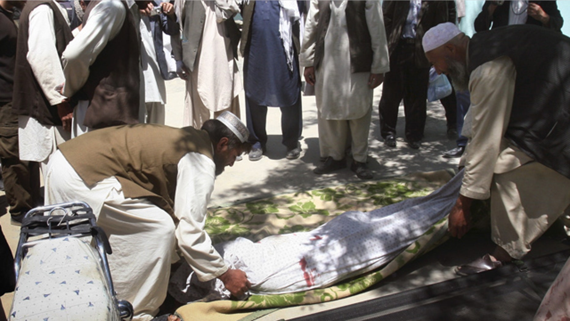 May 1, 2011: Relatives wrap the body of a civilian who was killed during a clash of militants with policemen in Ghazni southwest of Kabul, Afghanistan.