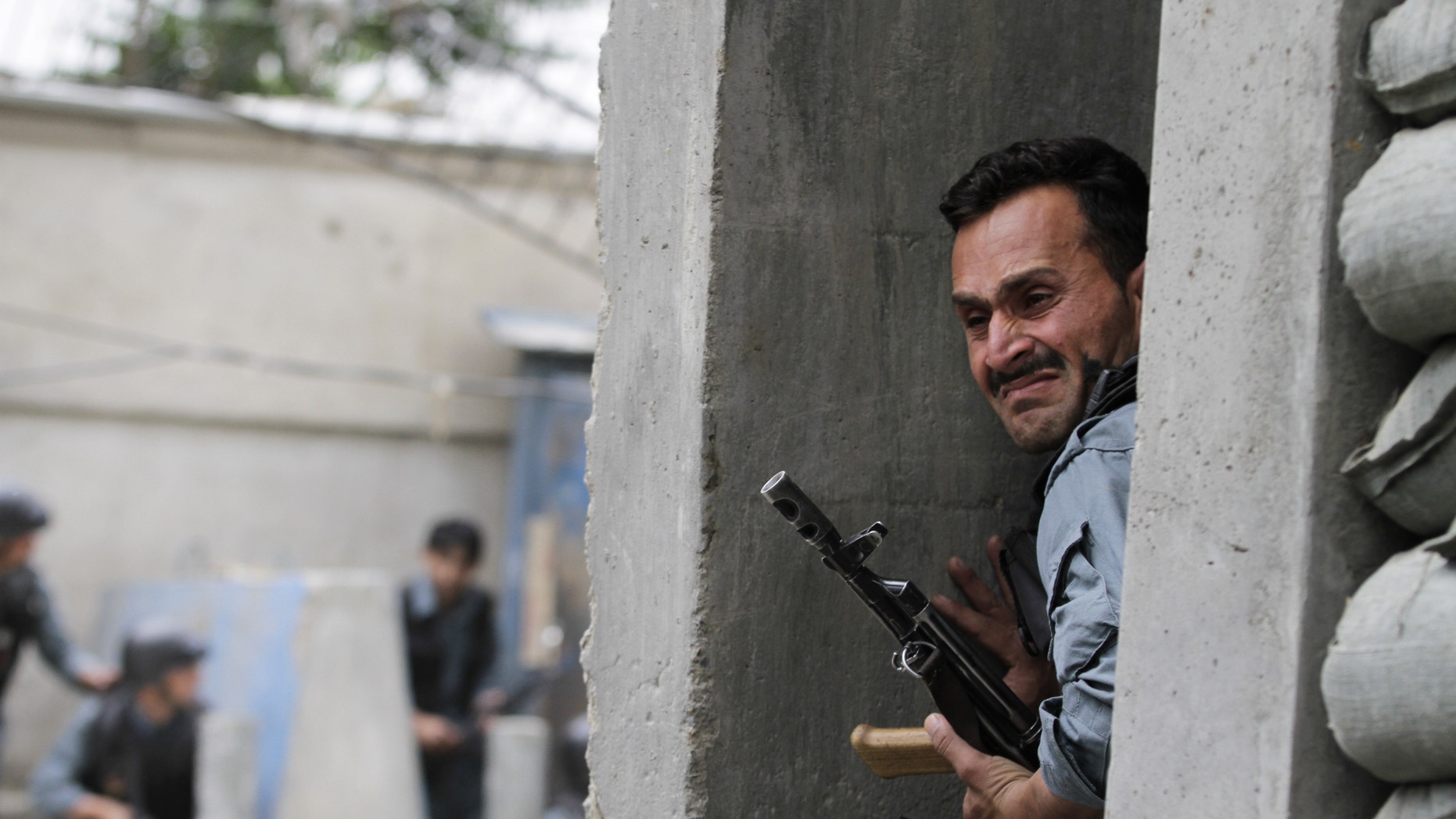 May 24, 2013 - An Afghan policeman takes cover following a suicide attack in Kabul, Afghanistan.