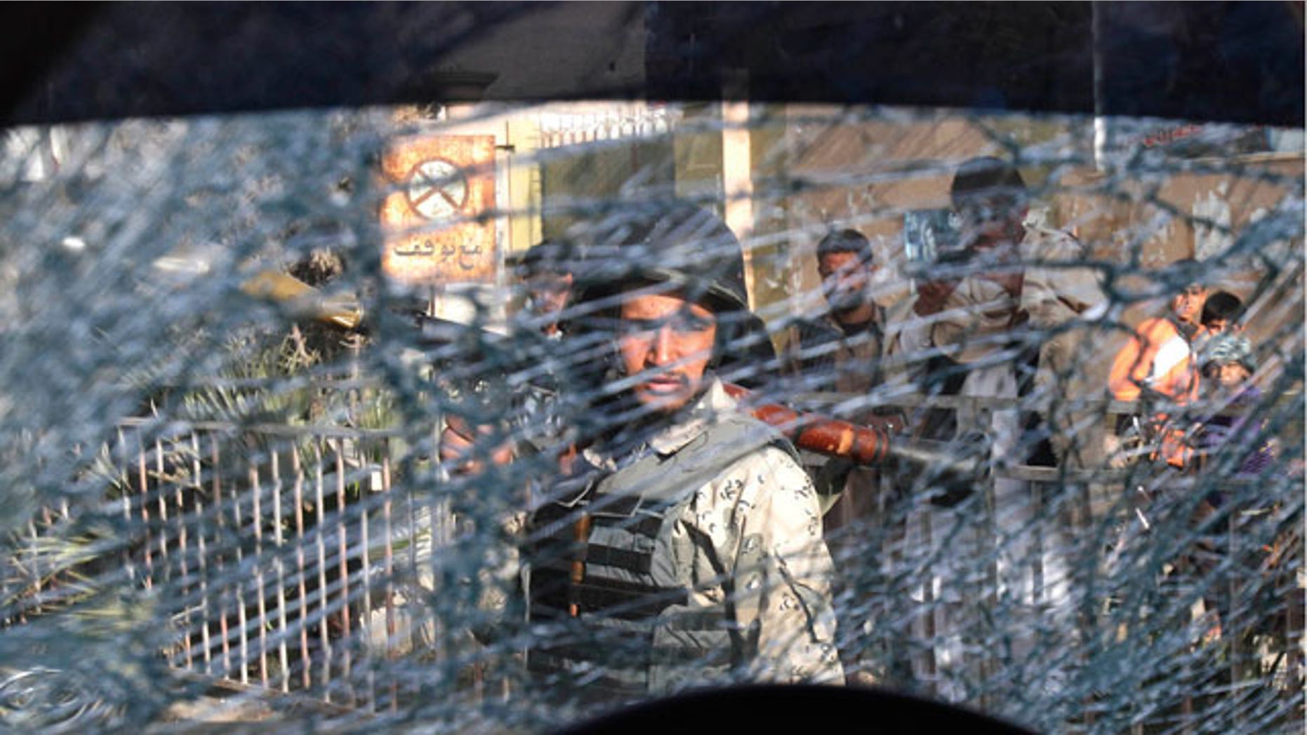 Mar. 6, 2012: An Afghan soldier passes by a chattered window of a destroyed police car after an explosive device went off in the center of Jalalabad, east of Kabul, Afghanistan.