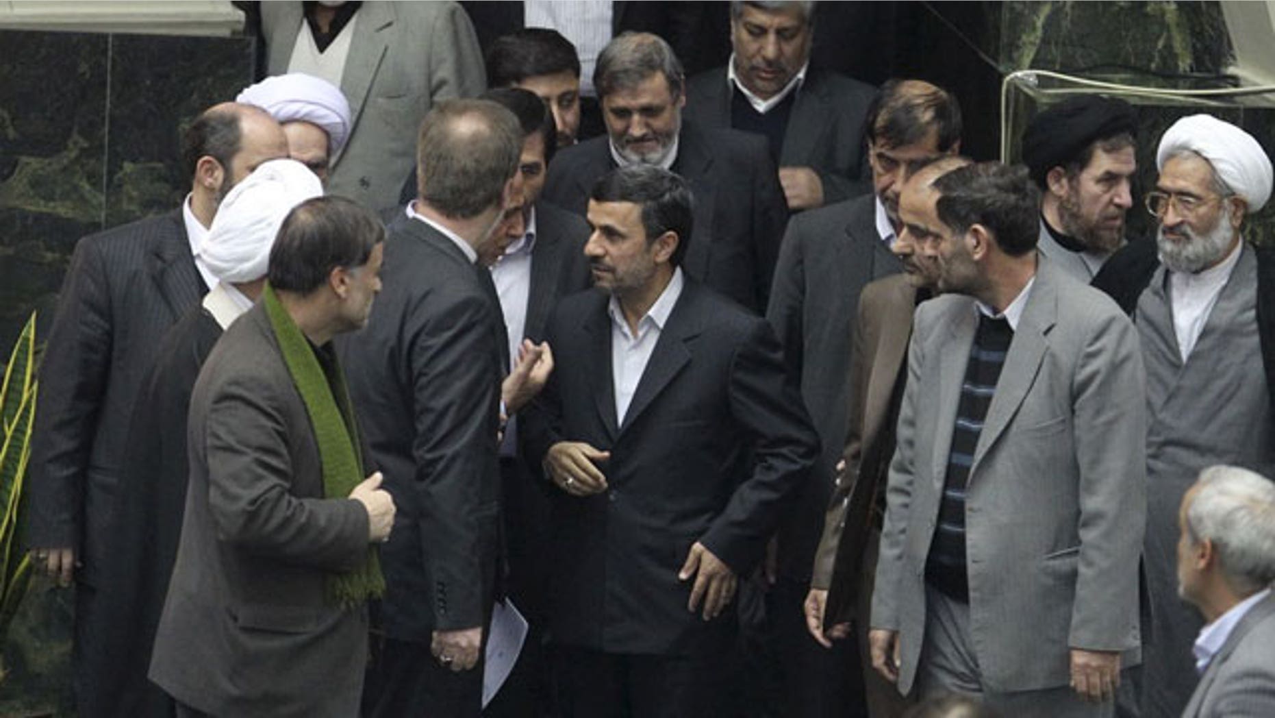 Feb. 1, 2012: In this photo released by the official website of the Iranian President's office, Iranian President Mahmoud Ahmadinejad, center, arrives at the parliament to deliver the new year's budget, as he is surrounded by lawmakers, in Tehran, Iran.