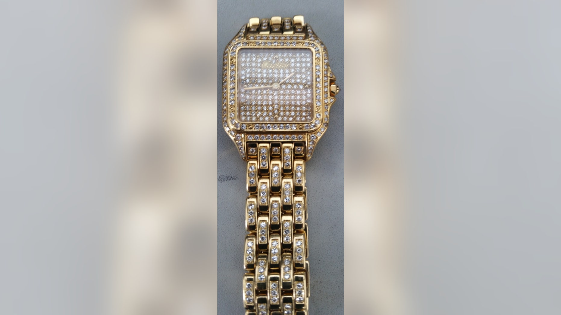 This May 5, 2015 photo provided by the Transportation Security Administration shows a diamond-encrusted Cartier watch that was left behind at a security checkpoint at Newark Liberty International Airport in Newark, N.J. Guards got a surprise when they looked in a bin and discovered the watch valued at more than $100,000 when a real estate entrepreneur from Japan left it behind as he boarded a flight back home in Terminal C on Tuesday, May 5. A Transportation Security Administration officer put the watch under lock and key. (Transportation Security Administration via AP)