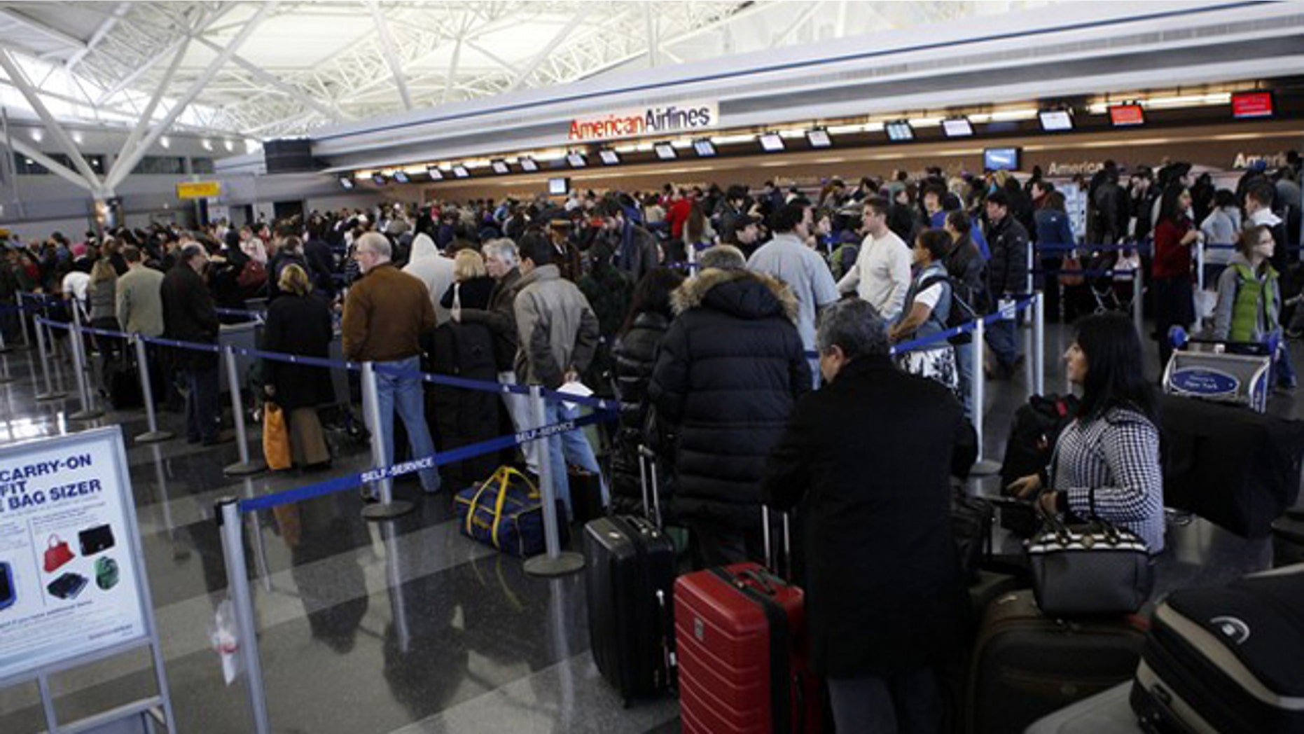 Passengers wait in line for ticketing at the John F. Kennedy International Airport as the airport reopened after being closed due to heavy snowfall in New York, January 27, 2011. REUTERS/Jessica Rinaldi (UNITED STATES - Tags: ENVIRONMENT TRANSPORT)