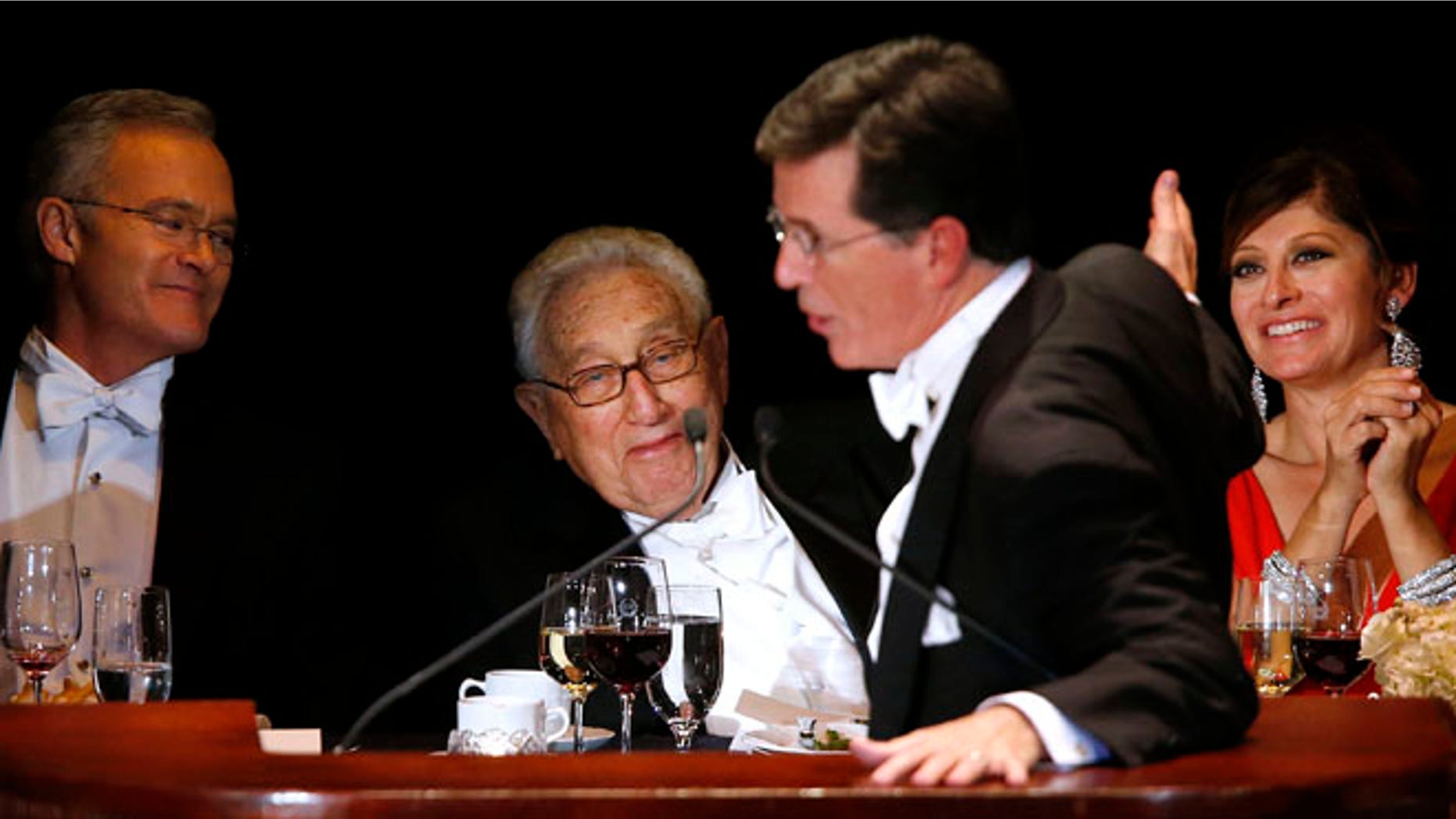 Oct. 17, 2013: Keynote speaker Stephen Colbert pokes fun at former U.S. Secretary of State Henry Kissinger, center, and CNBC anchor Maria Bartiromo, right, as CBS Evening News anchor Scott Pelley, left, looks on during the Alfred E. Smith Memorial Foundation Dinner, a charity gala organized by the Archdiocese of New York, at the Waldorf-Astoria hotel, in New York.