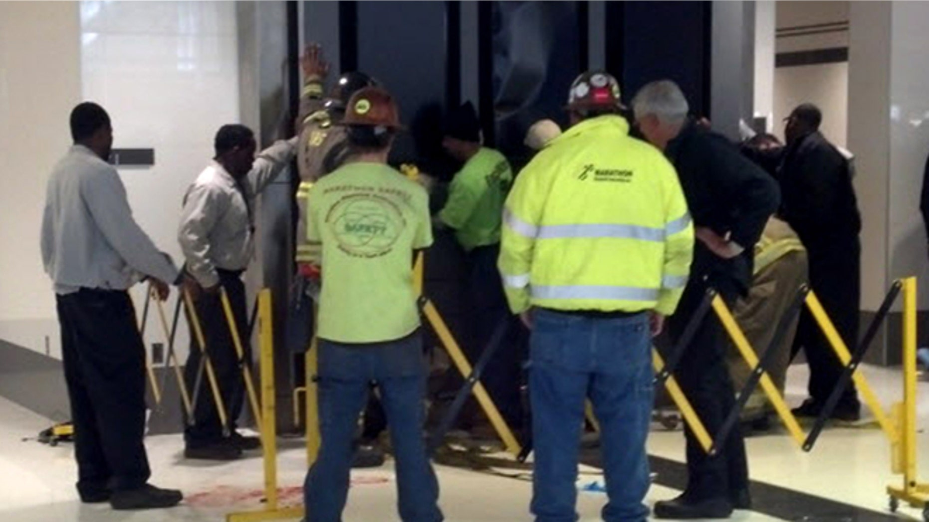 March 22: People hold up a message board sign that fell on a family killing a child and injuring the mother and two other children in the terminal at the Birmingham-Shuttlesworth International Airport in Birmingham, Ala.