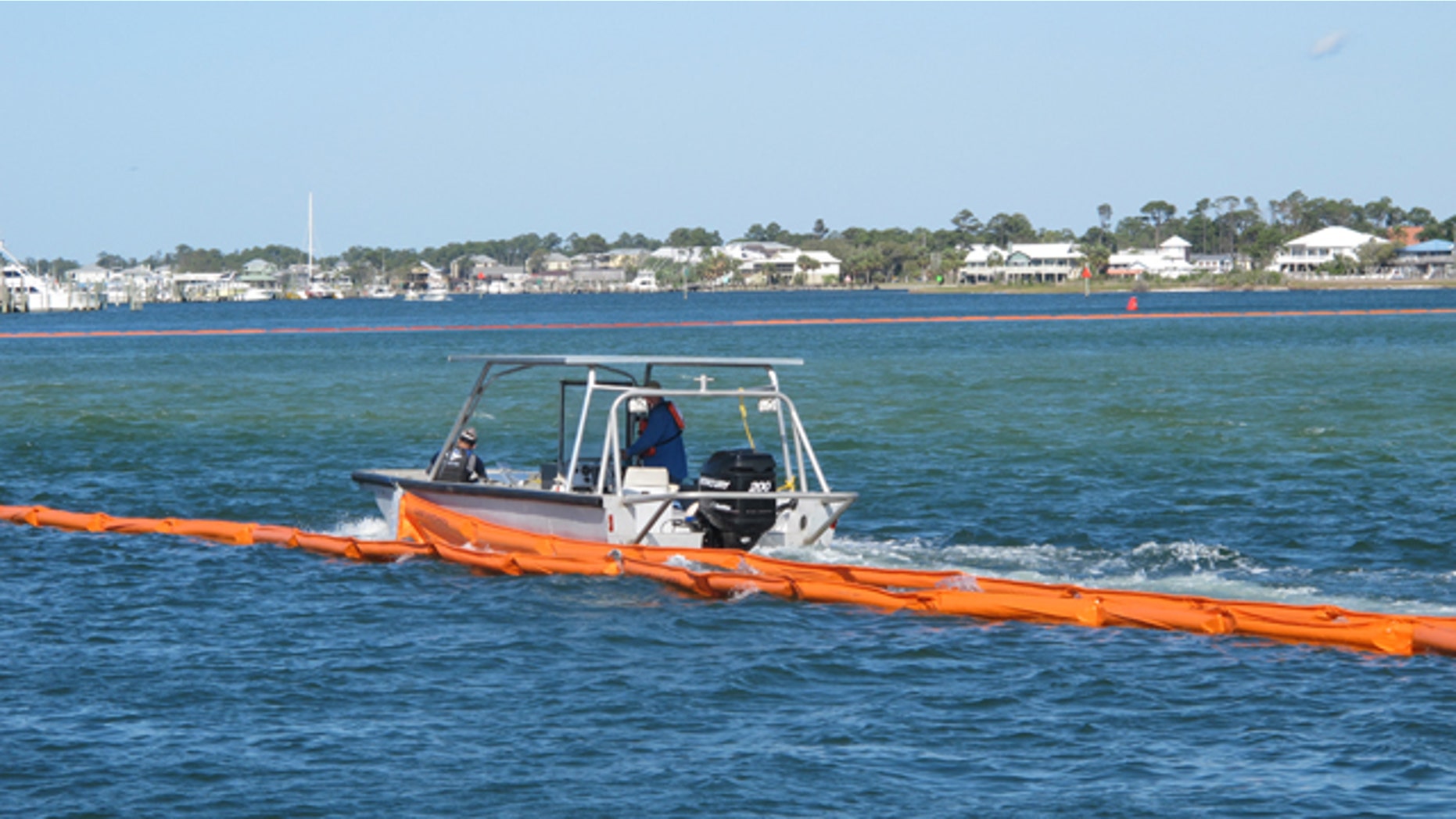 April 29, 2010: Workers in Orange Beach, Ala., lay inflatable orange booms to protect the beach and wildlife against a massive oil spill nearing the coastline.
