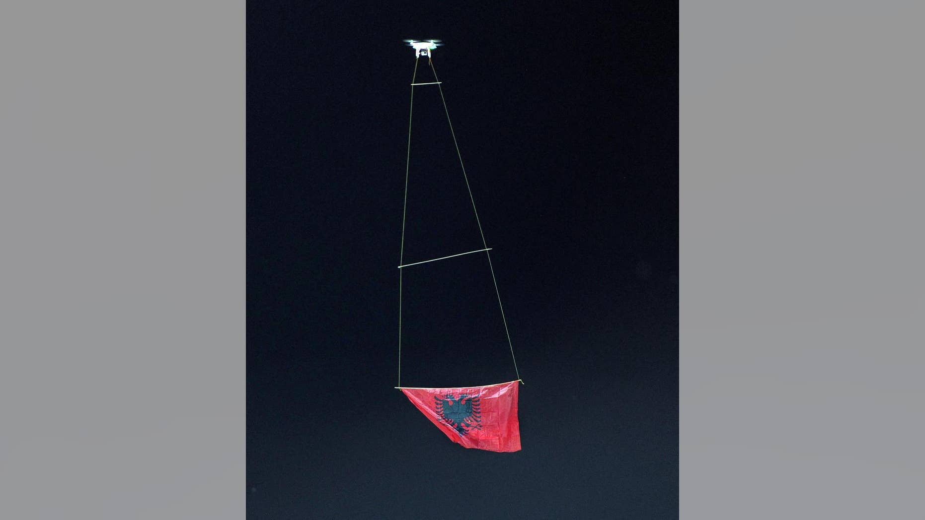 A drone flies an Albanian flag at the national league match in Vlora, 140 kilometers (85 miles) southwest of capital Tirana, between local Flamurtari FC vs. KF Skenderbeu, Friday, Oct. 17, 2014. The game ended 1-1. Earlier this week a drone that flew an Albanian nationalist banner over a soccer stadium in Belgrade, Serbia ignited a brawl when Albanian players who tried to protect it were attacked by Serb counterparts, fans and security staff on the pitch, forcing the referee to abandon the match. (AP Photo/str)