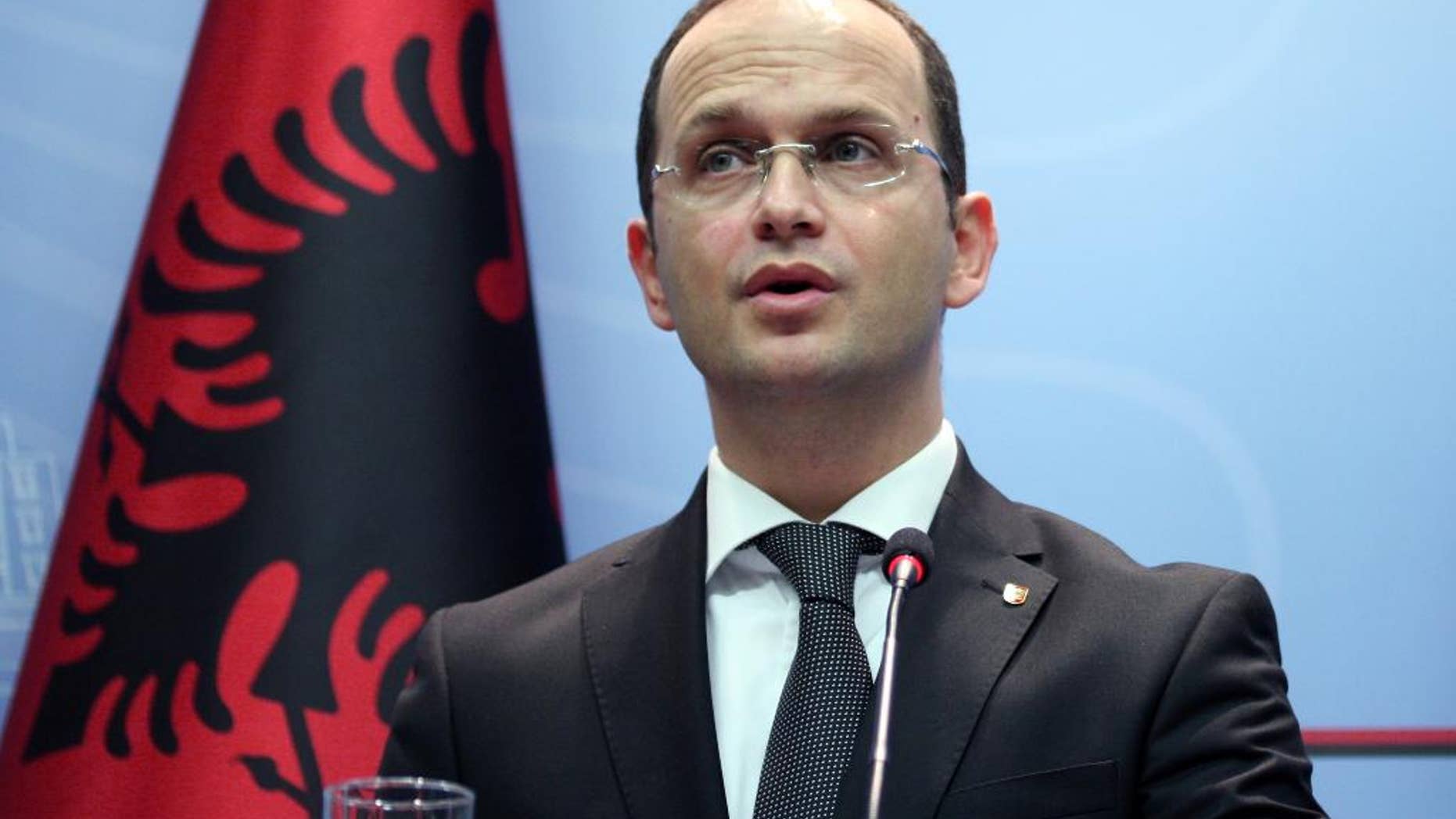 Albanian Foreign Minister Ditmir Bushati speaks at a news conference in capital Tirana, Albania Wednesday, Oct. 15, 2014, strongly denouncing anti-Albanian slogans and the violence before, during and after the match with Serbia. It was all about the drone Wednesday — the one that took off from an Orthodox Church in Belgrade and flew over a soccer stadium with a nationalist Albanian banner. It ignited more than a brawl between players and fans — it inflamed years of simmering tensions between Balkan rivals Serbia and Albania. (AP Photo/Hektor Pustina)