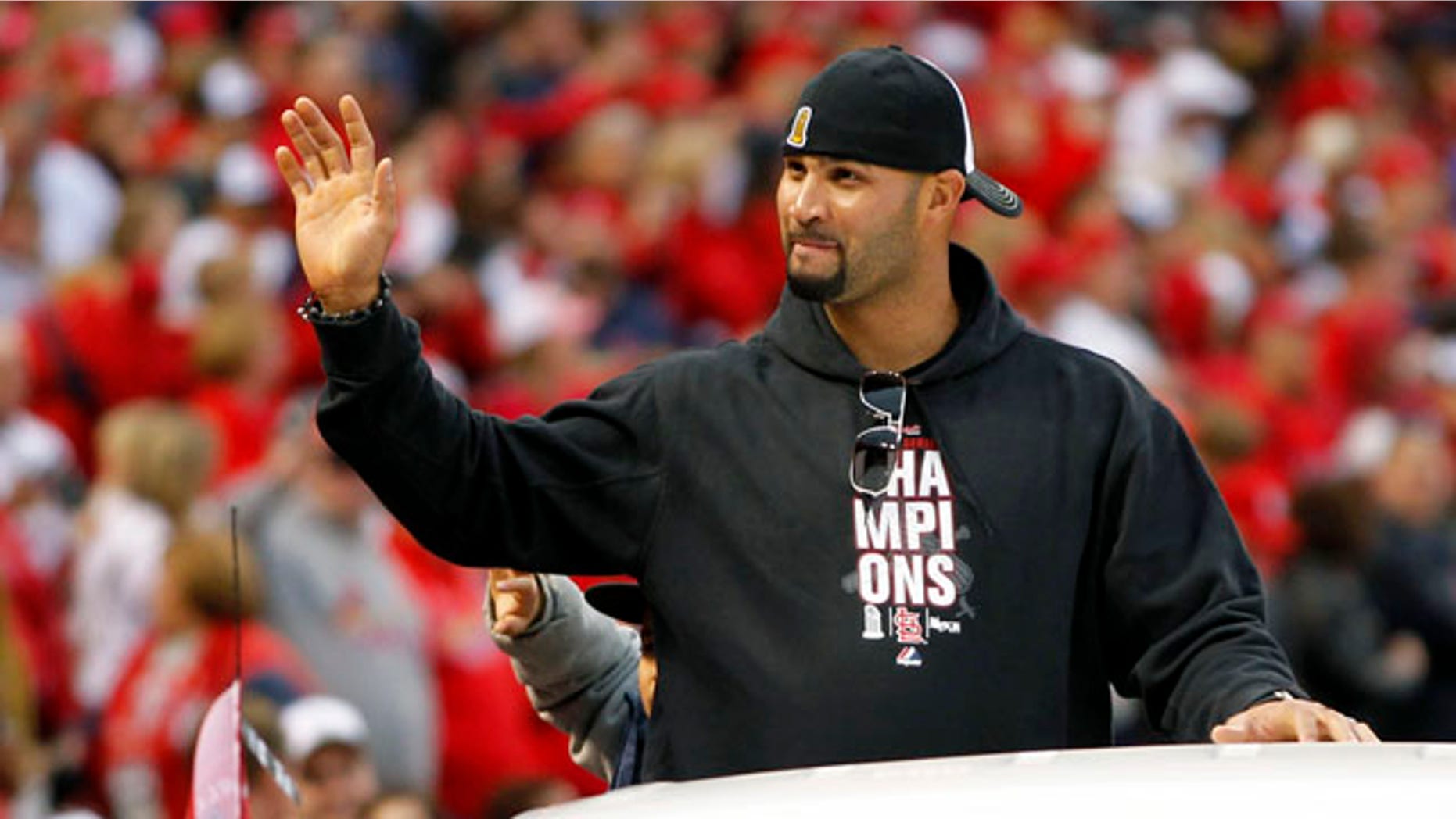 St. Louis Cardinals' Albert Pujols waves to fans at Busch Stadium during a victory parade in celebration of the Cardinals' 11th World Series victory, Sunday, Oct. 30, 2011, in St. Louis. The free agent has reportedly been wooed by the Cardinals and the Marlins. (AP Photo/Jeff Roberson)