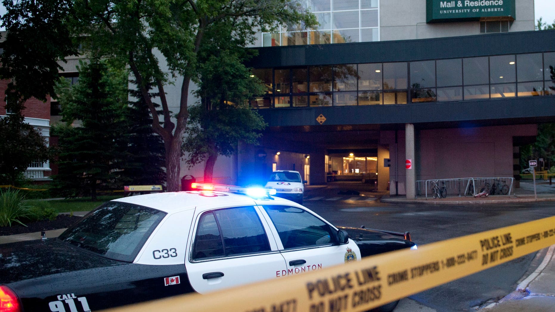 Police investigate the scene after three people were killed in an apparent attempted armed robbery at the University of Alberta in Edmonton, Canada on Friday, June 15, 2012. The robbery happened in the Hub Mall area, which is a combination of student residences and 54 shops. (AP Photo/The Canadian Press, Ian Jackson)