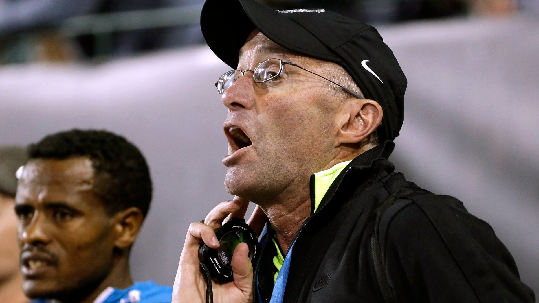 Former distance runner Alberto Salazar yells out lap times to distance runner Mo Farah, from Britain, during the 10,000-meter race in the Prefontaine Classic track and field meet in Eugene, Ore., Friday, May 29, 2015. Farah, who is coached by Salazar, won the race with a time of 26:50.97. (AP Photo/Don Ryan)