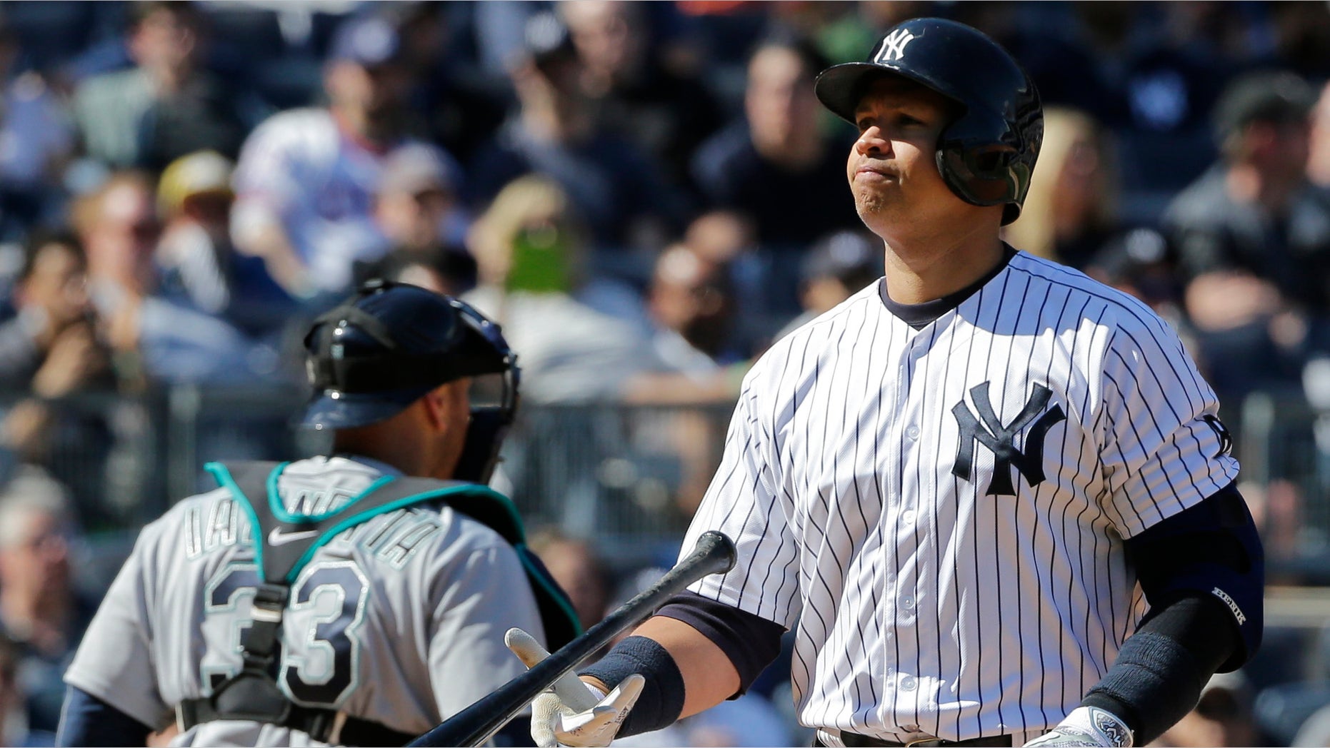 New York Yankees' Alex Rodriguez flips his bat after striking out during the sixth inning of a baseball game as Seattle Mariners catcher Chris Iannetta (33) walks toward the dugout Saturday, April 16, 2016, in New York. (AP Photo/Frank Franklin II)