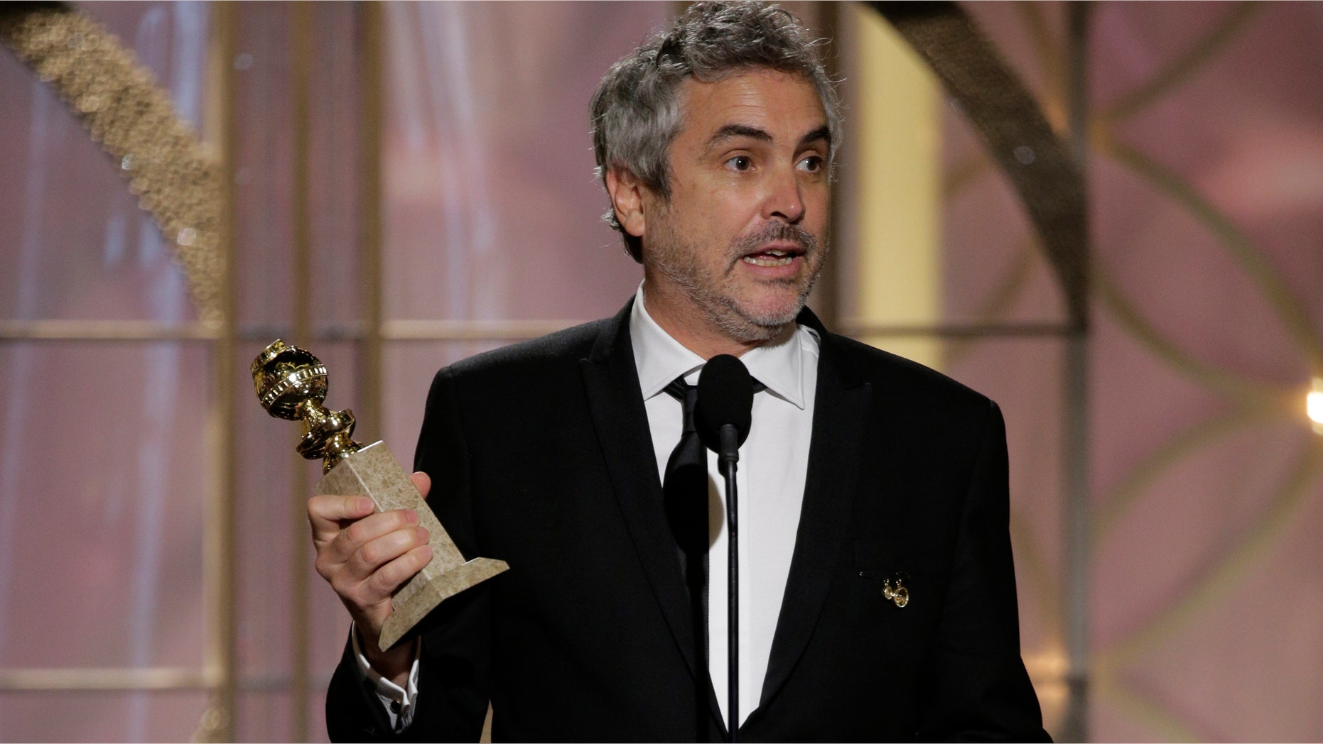 BEVERLY HILLS, CA - JANUARY 12: In this handout photo provided by NBCUniversal, Alfonso Cuaron accepts the award for Best Director - Motion Picture for "Gravity" during the 71st Annual Golden Globe Award at The Beverly Hilton Hotel on January 12, 2014 in Beverly Hills, California. (Photo by Paul Drinkwater/NBCUniversal via Getty Images)