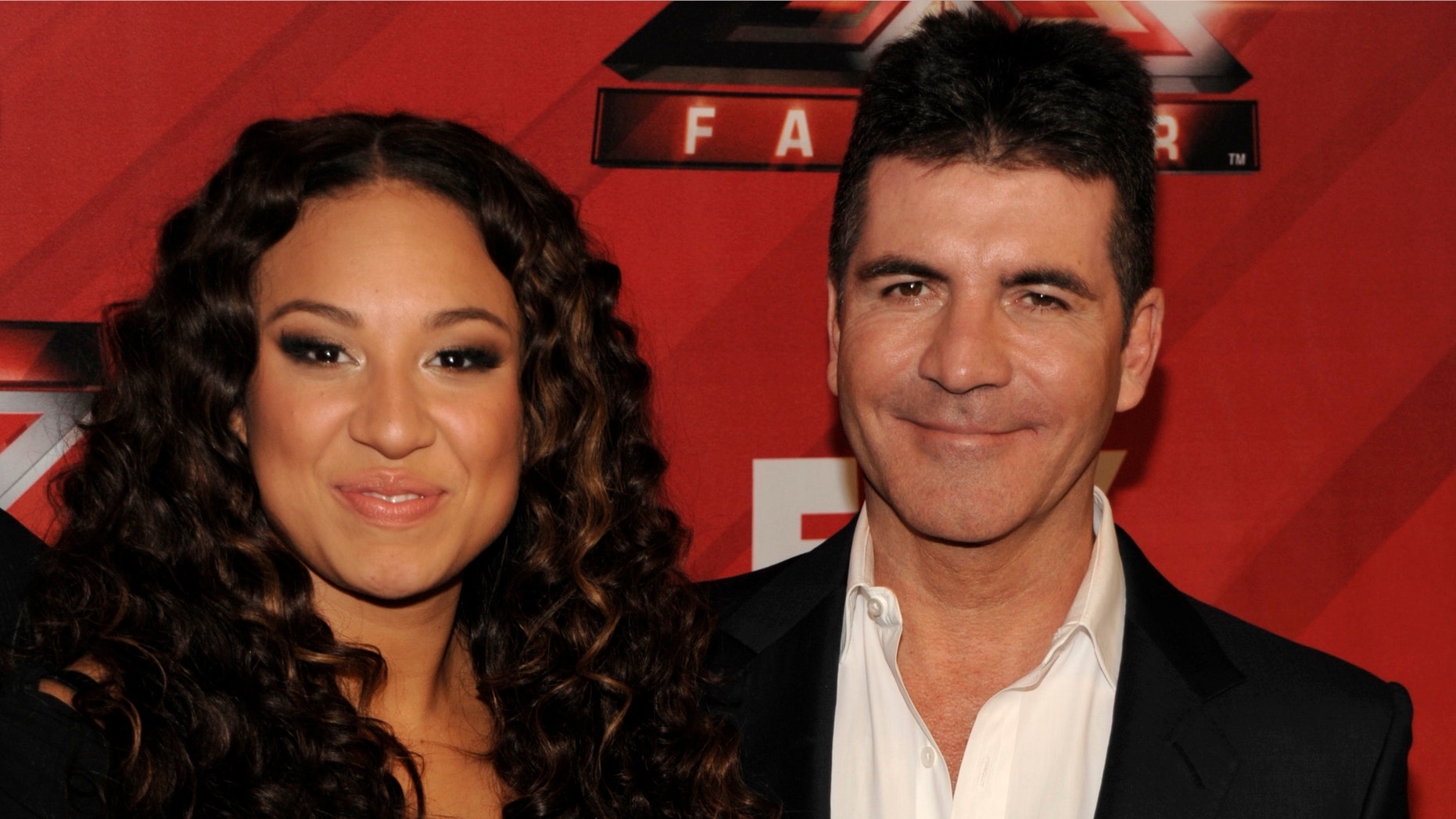 Singer Melanie Amaro, left, and television personality Simon Cowell pose together on the red carpet at The X Factor Finale show in Los Angeles on Thursday, Dec. 22, 2011. Amaro was chosen as the winner for the first season of the show. She will be awarded with a $5 million record deal and a Pepsi ad campaign.(AP Photo/Dan Steinberg)