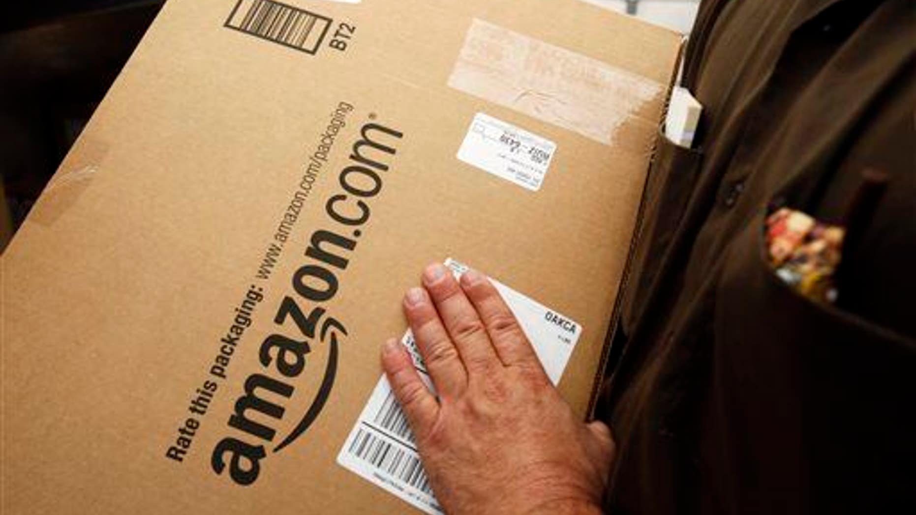 In this Oct. 18, 2010 file photo, an Amazon.com package is prepared for shipment by a United Parcel Service driver in Palo Alto, Calif.