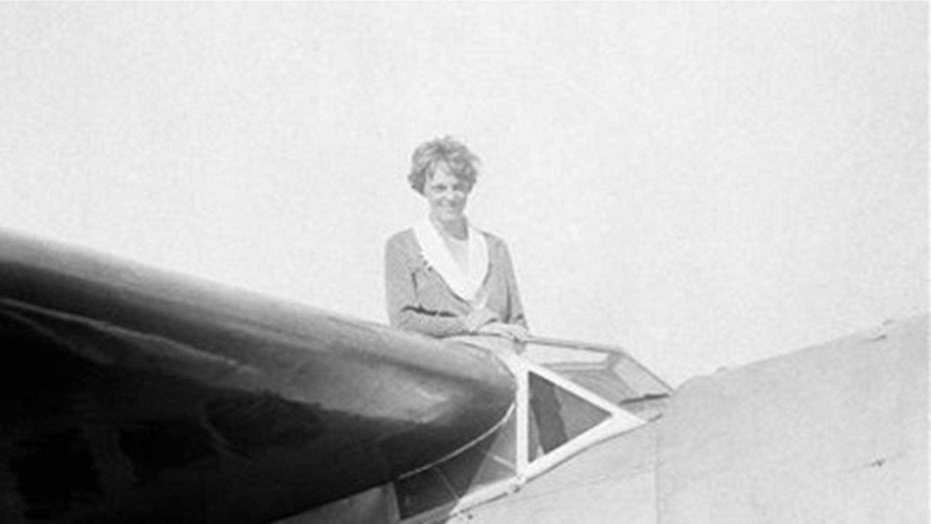 FILE: In this undated photo, Amelia Earhart, the first woman to cross the Atlantic Ocean by plane sits on top of a plane.